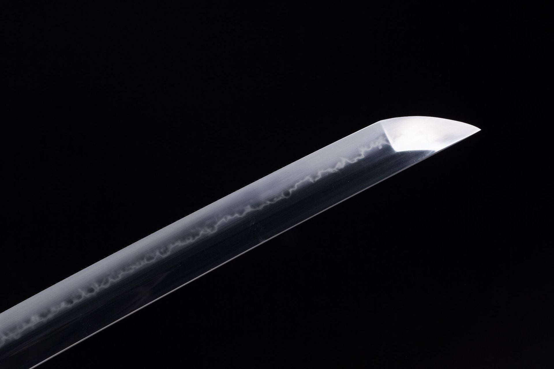 Close-up of the sharp edge tip and hamon texture on the Orochi katana blade.