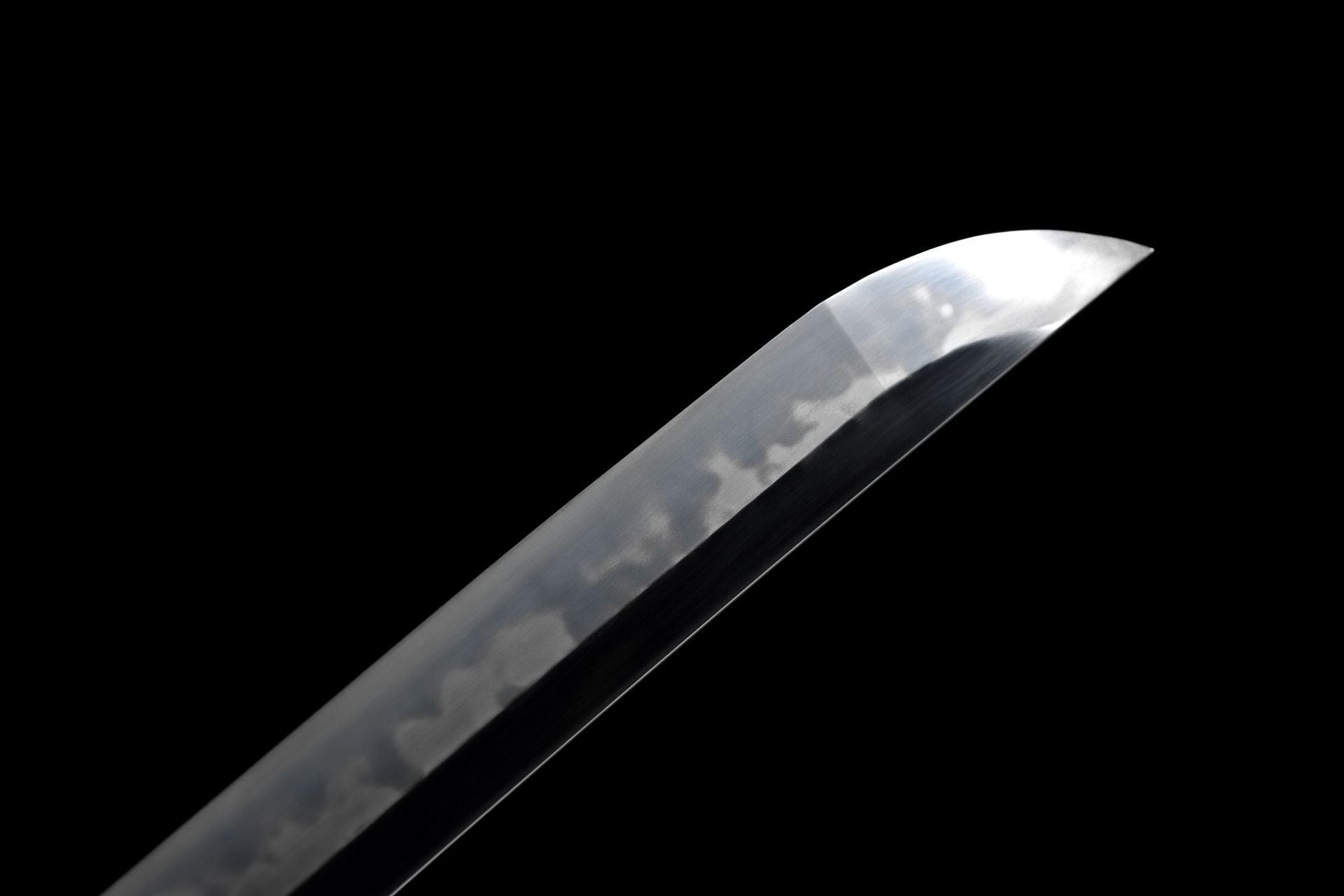 Detail of the tip of a Phoenix samurai sword, showcasing the polished blade and the unique hamon pattern.
