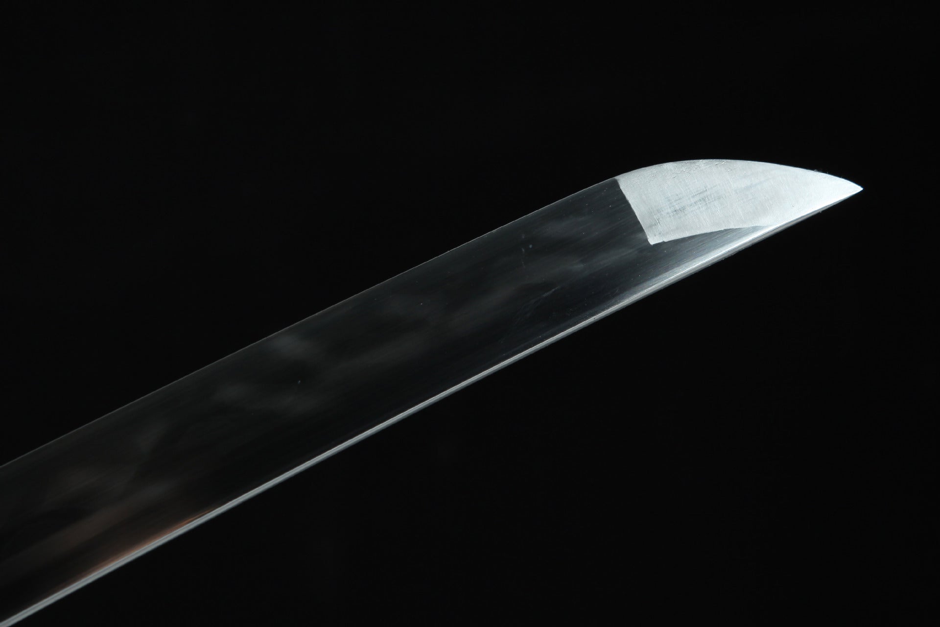 Closeup of the Sakura katana blade tip, showcasing the sharp edge and polished surface.