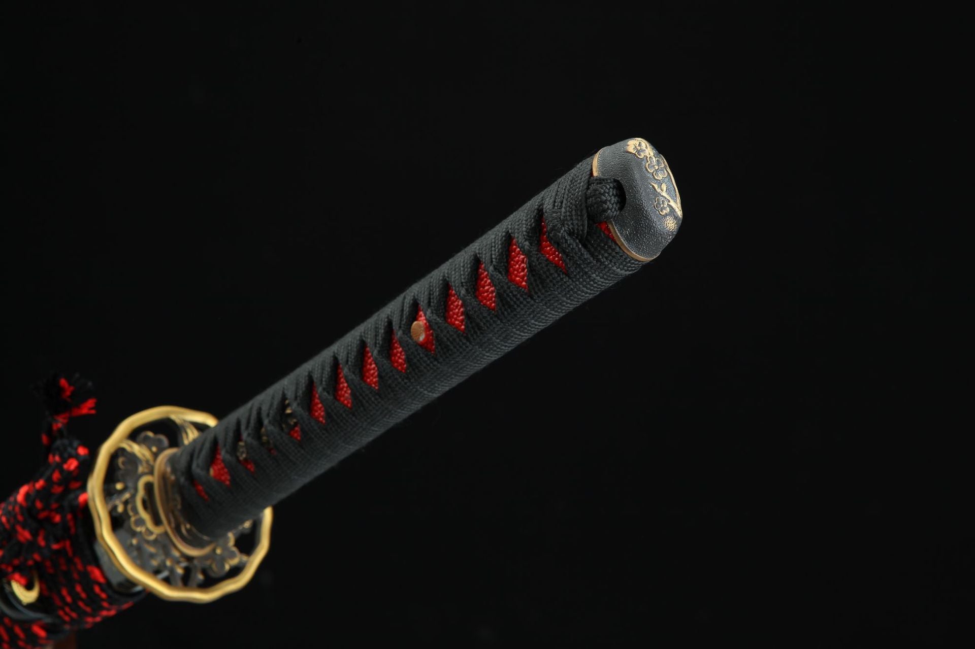 Closeup of the Sakura katana handle with black and red tsuka-ito and decorative kashira.