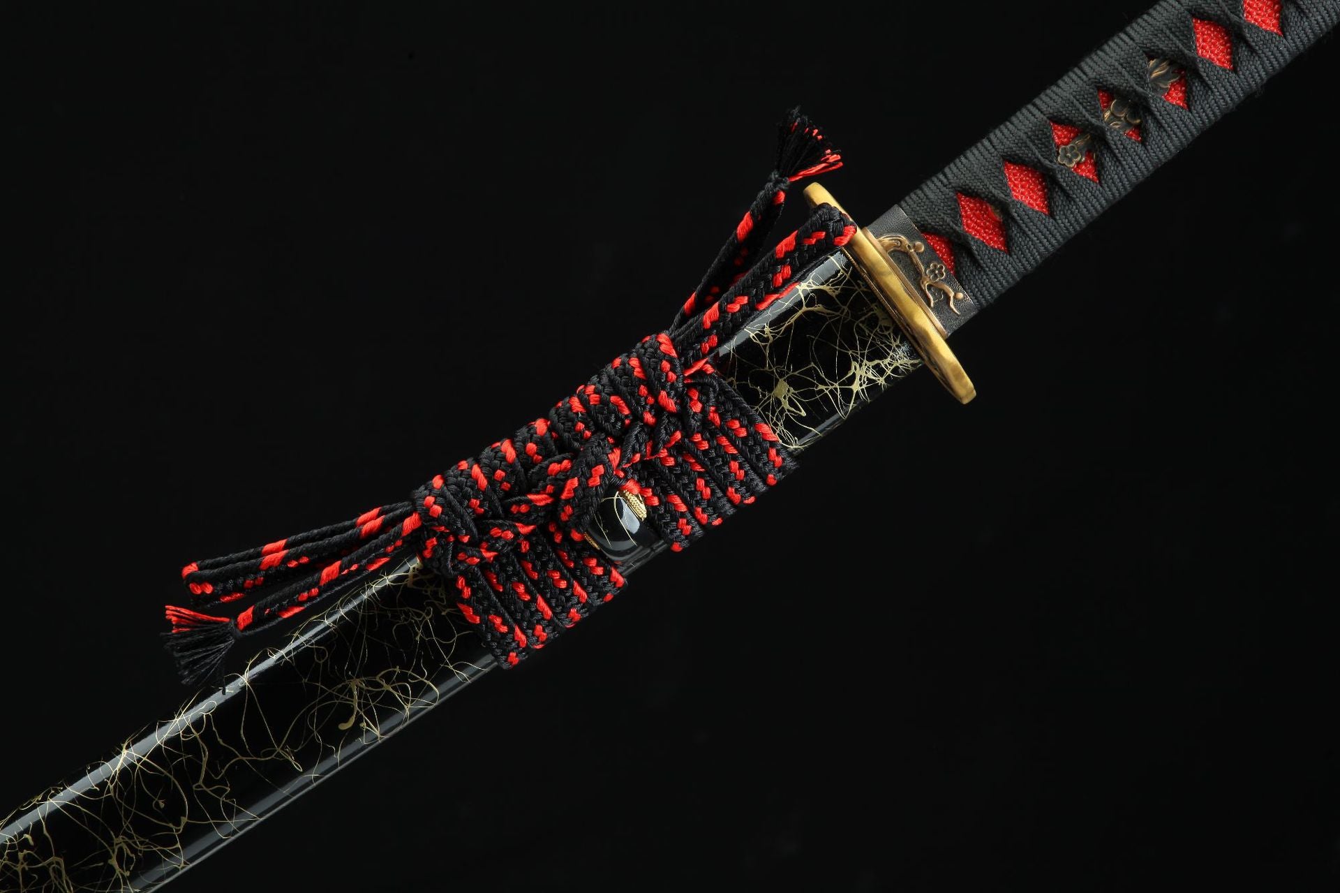 Closeup of the Sakura katana sageo with intricate black and red knotting design on the decorated saya.