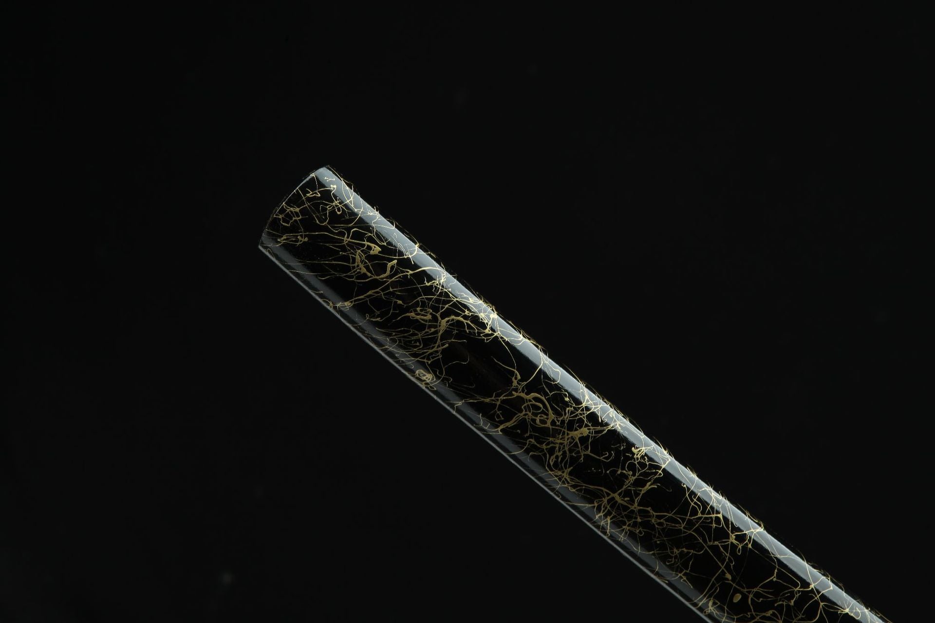 Closeup of the Sakura katana saya, featuring an intricate golden cracked design on the black surface.