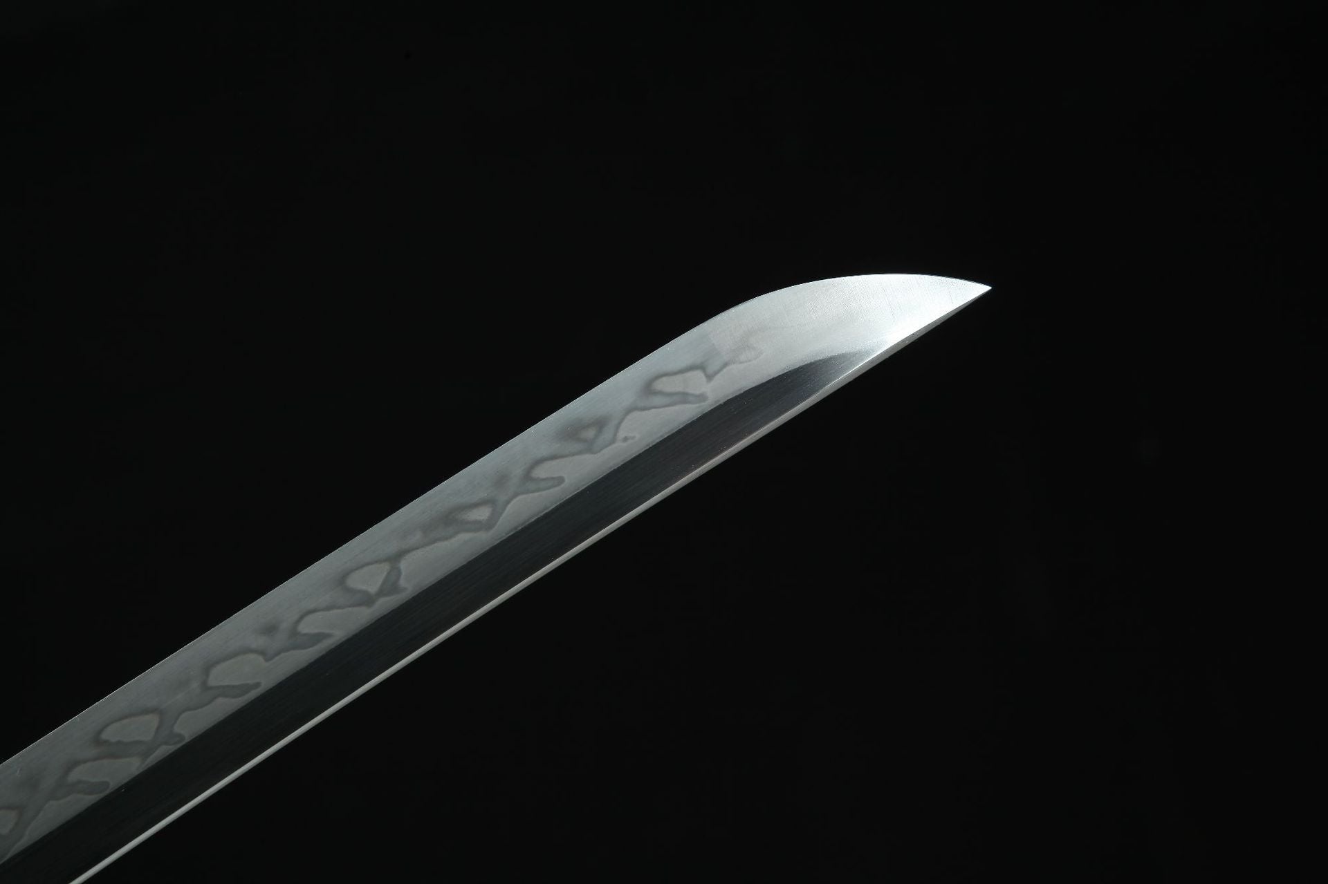 Closeup of Sakura X katana blade with hamon and sharp tip.