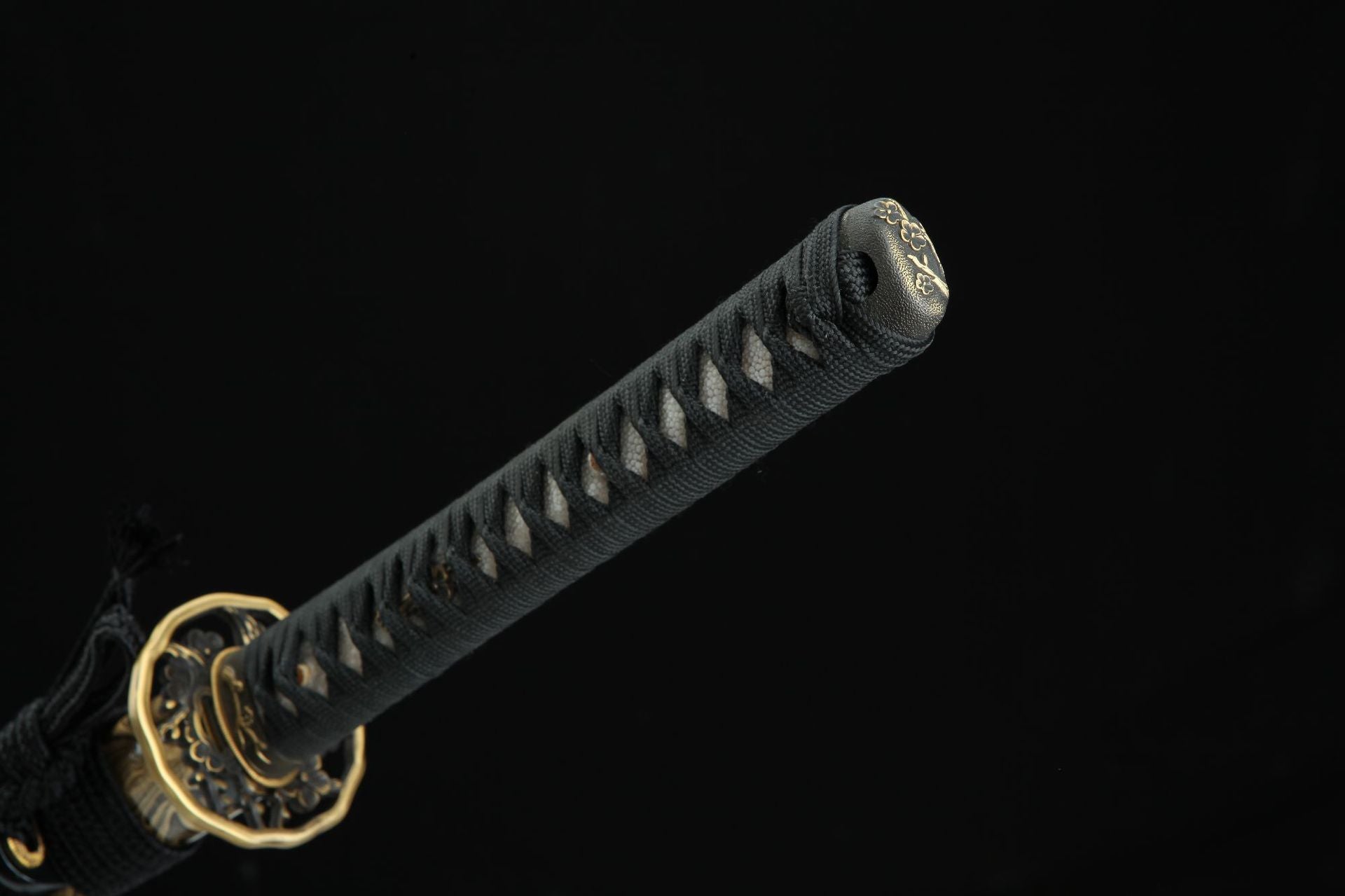Closeup of the Sakura X katana handle with black cord wrapping and decorative brass pommel.