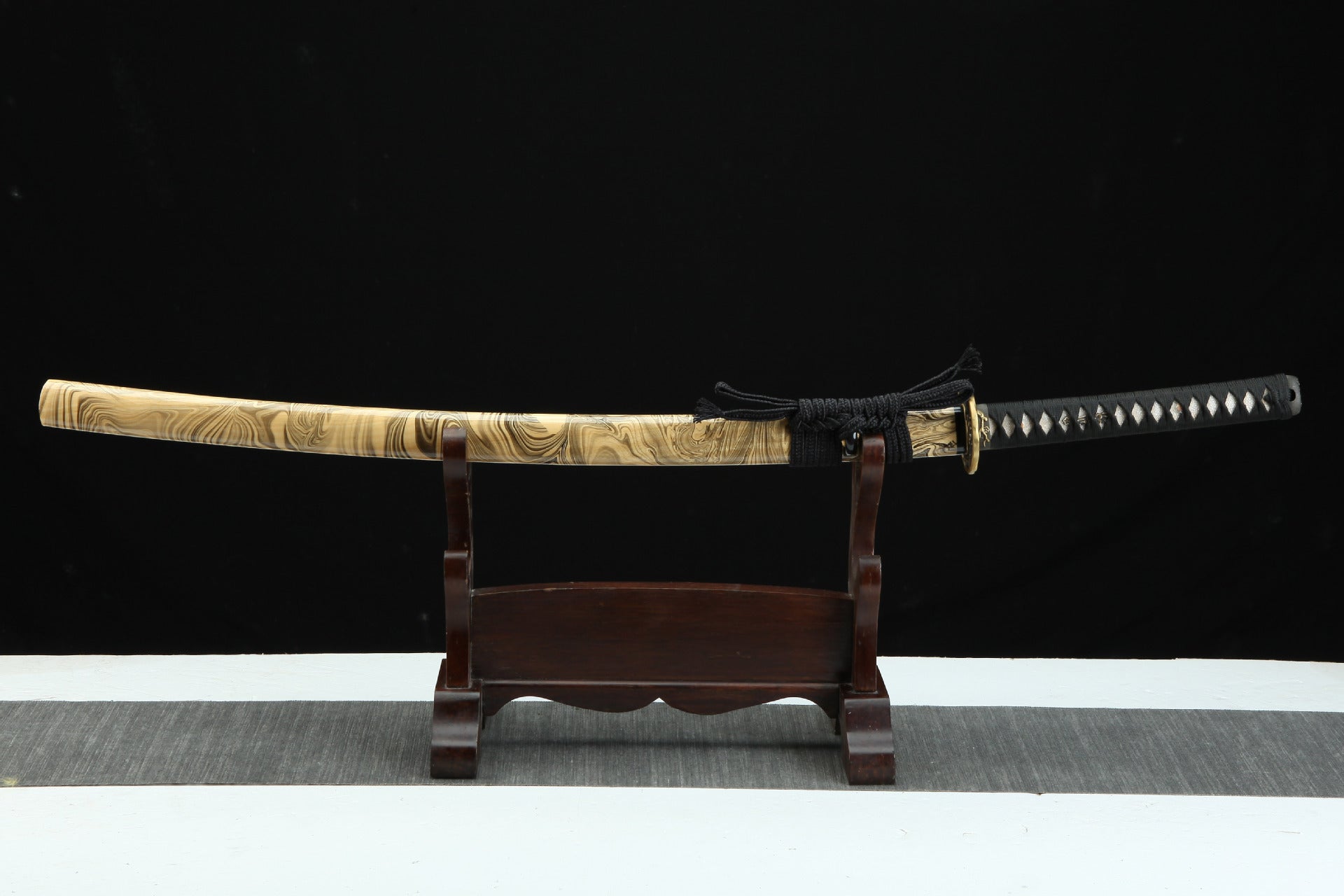 Full view of the Sakura X katana inserted into the saya, showing the unique marbled wood pattern and black cord wrap.