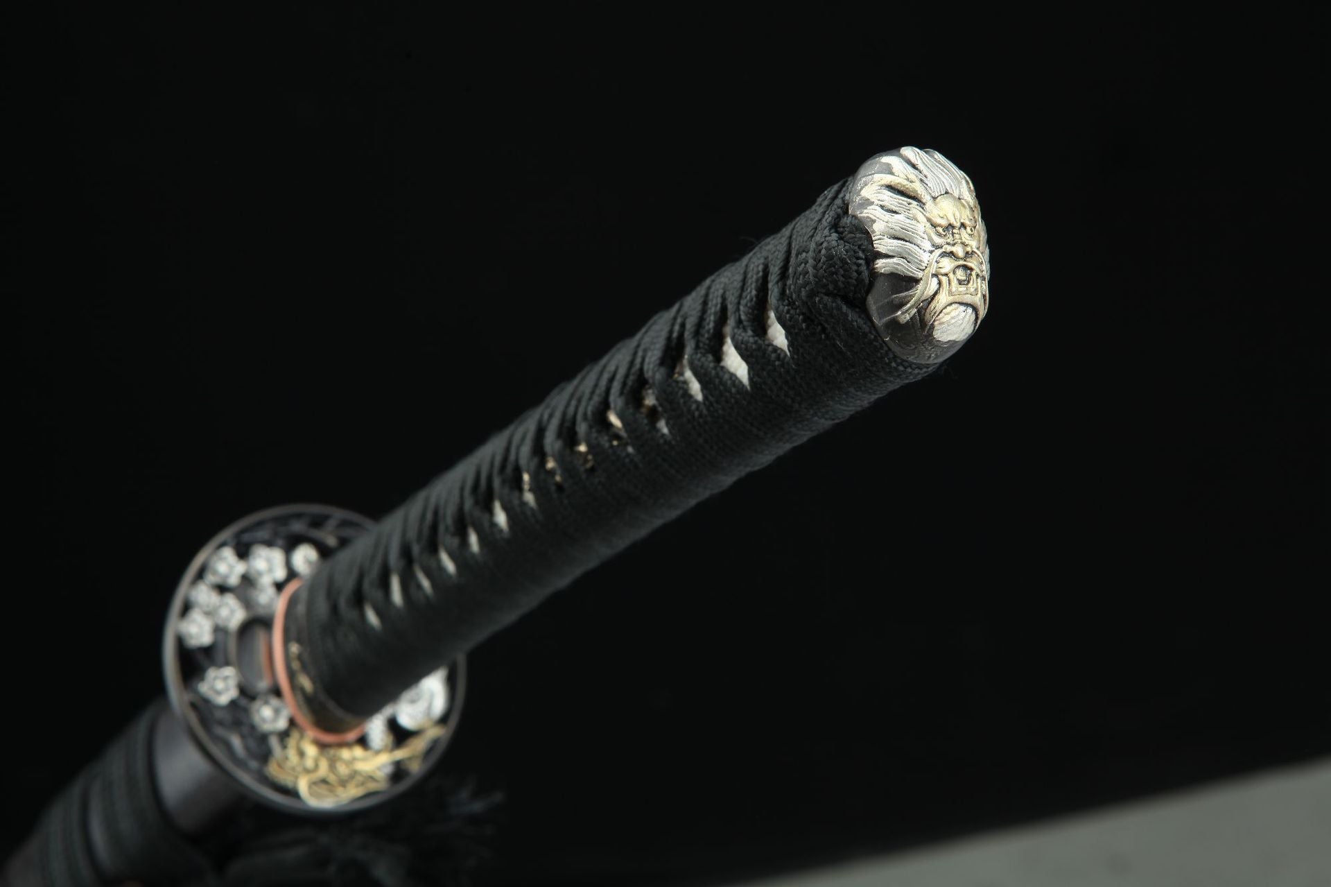 Close-up of the Ssangyong katana's kashira, engraved with a loong motif.