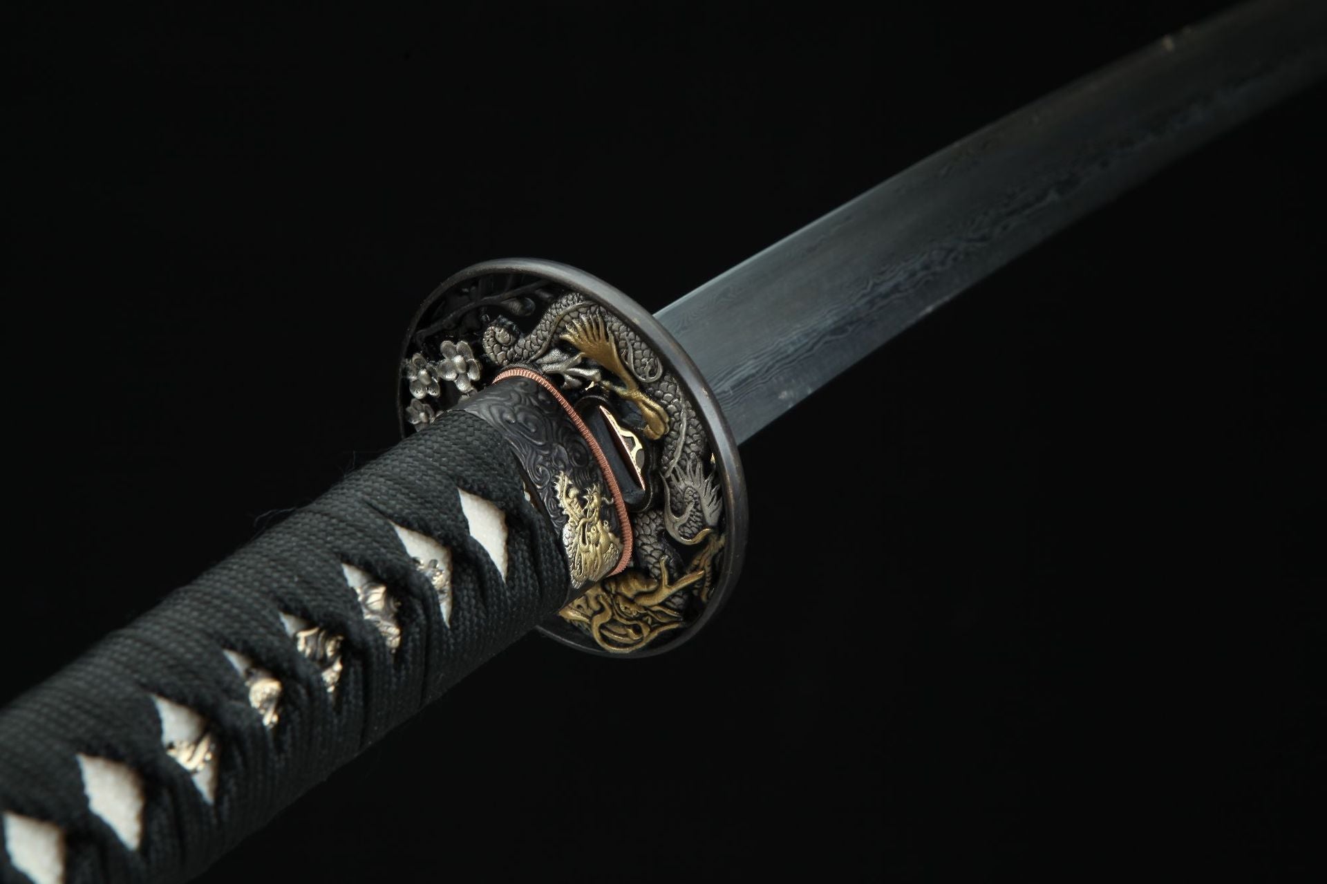 Close-up view of the Ssangyong katana's tsuba, intricately engraved with twin loongs.