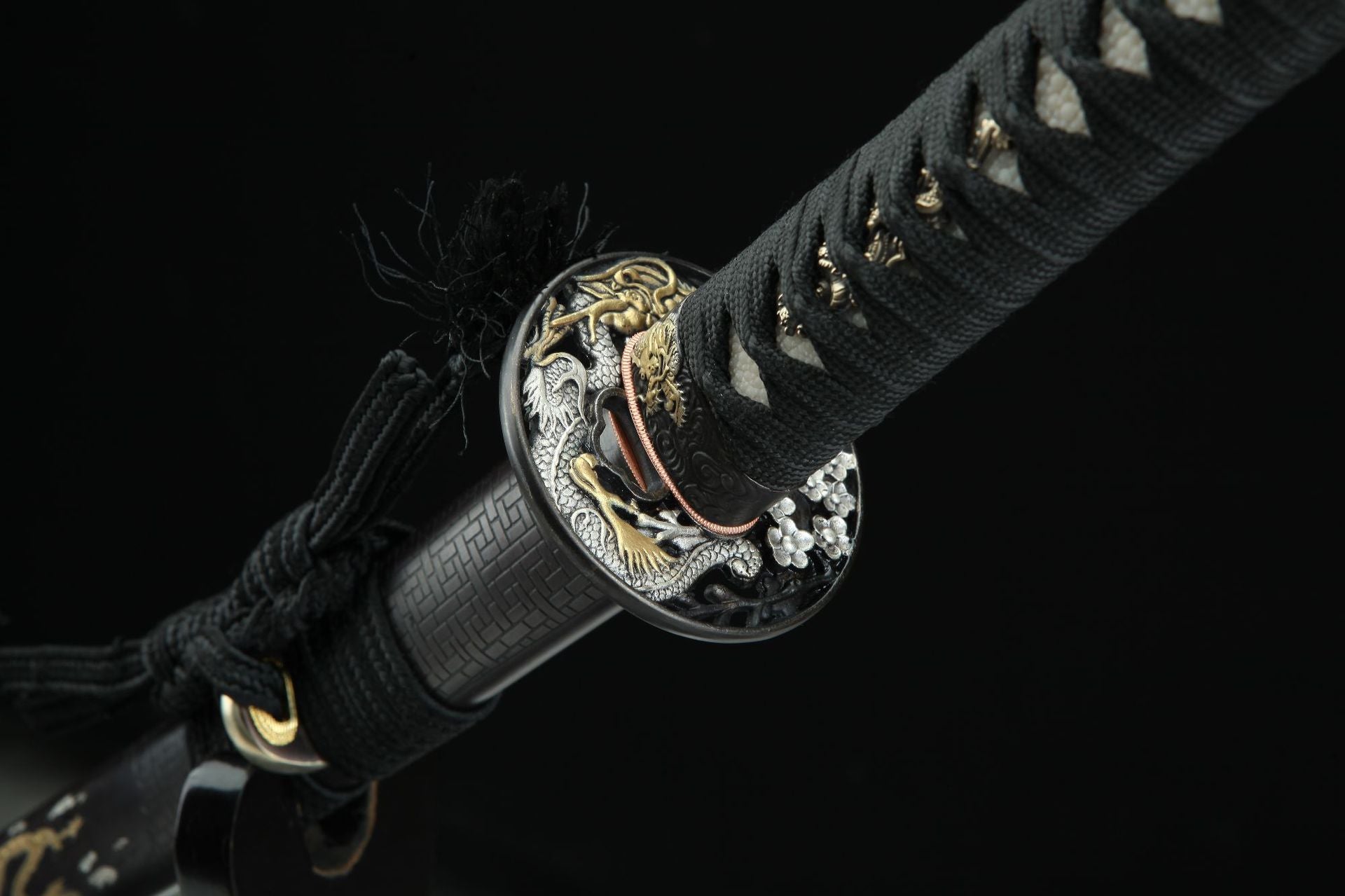 Ssangyong katana's tsuba featuring intricate engravings of two loongs in gold and silver.