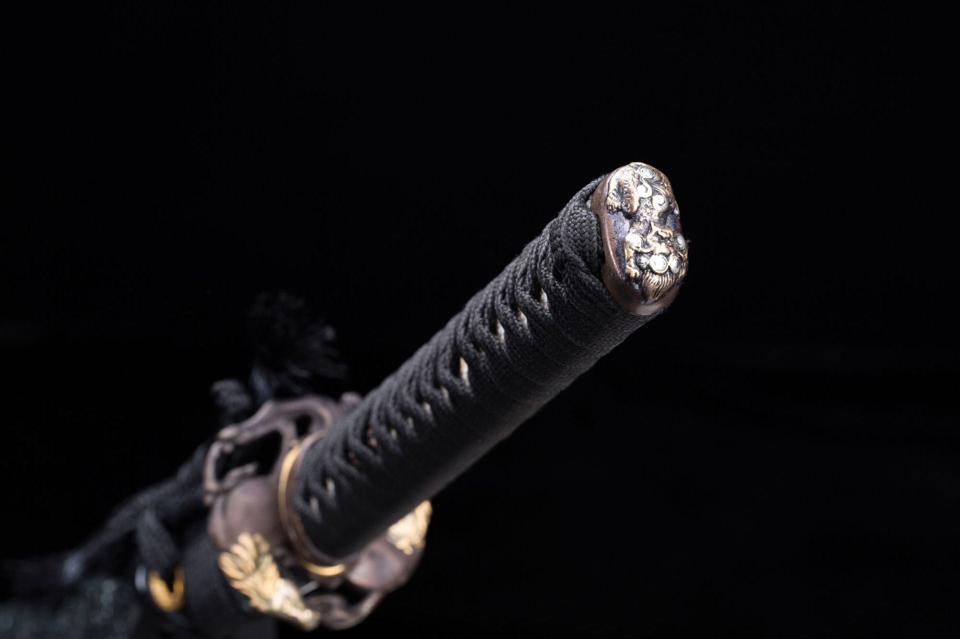 Samurai sword pommel with intricate metal design.