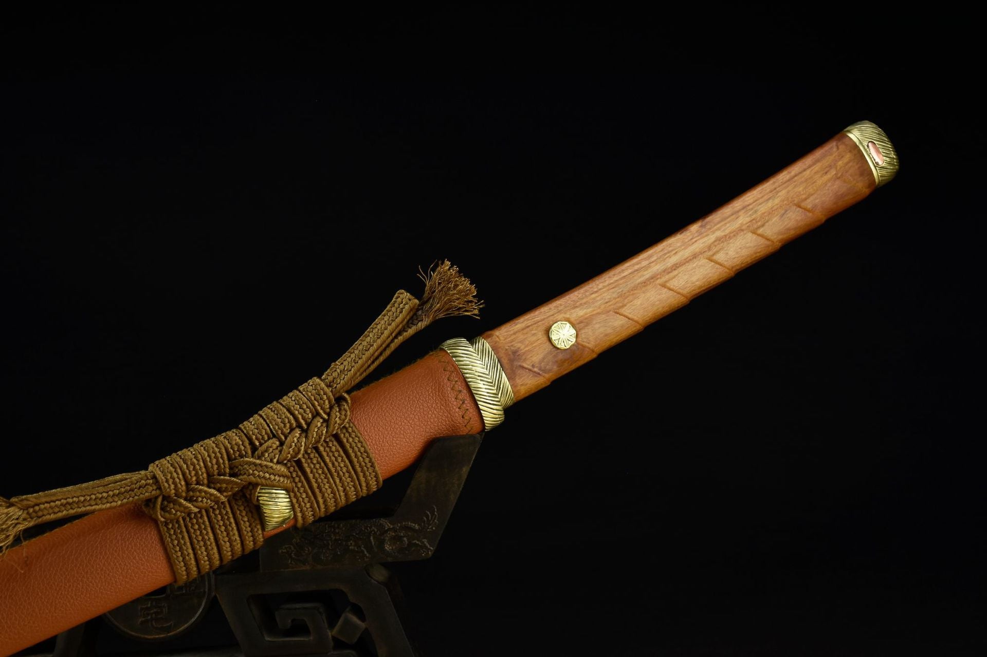 A katana featuring a polished wooden handle with brass fittings and a tan scabbard, wrapped in decorative cord for a refined traditional look.