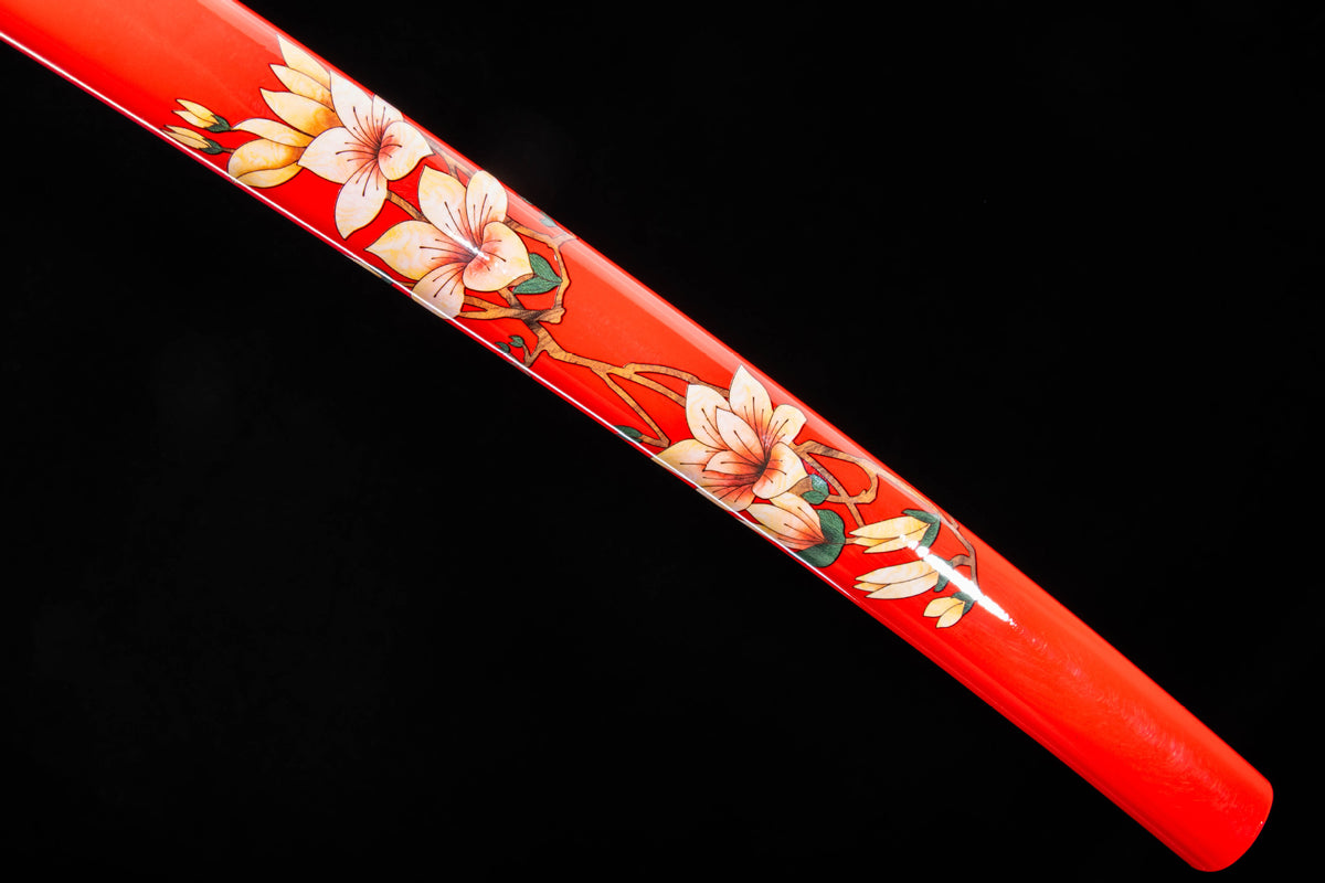 Close-up of the Crimson Blossom Katana’s red lacquer saya with pale blossom artwork