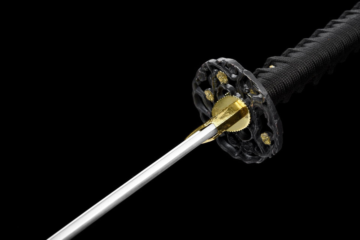 Angled view of Kuro Katana guard, gold-tone fittings, and black cord-wrapped handle