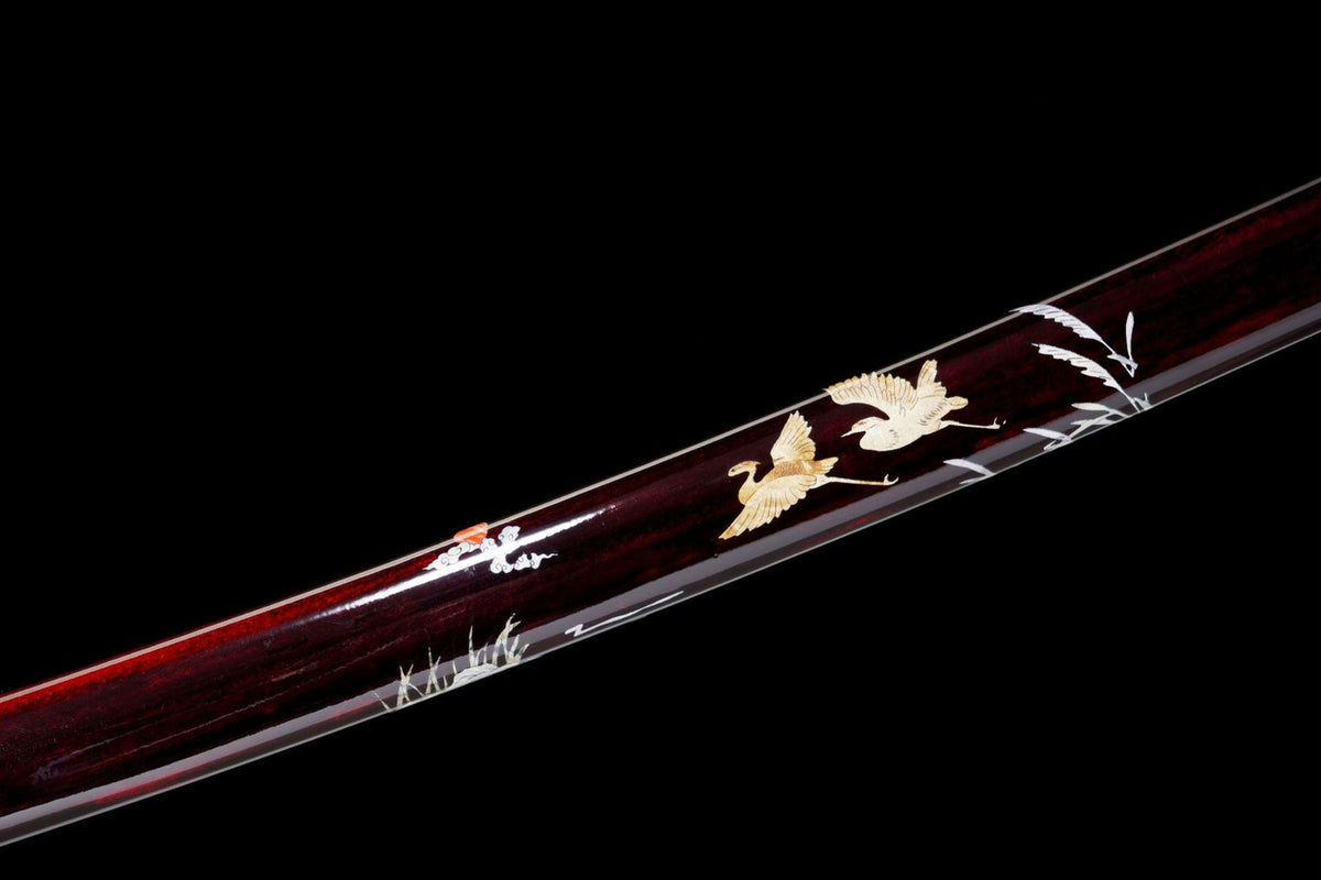 Crane and grass artwork on the deep red saya