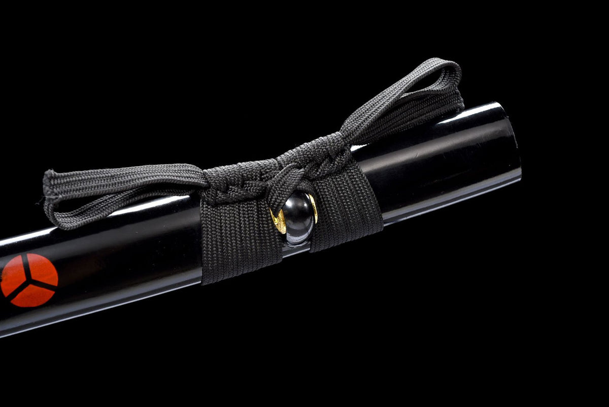 Close-up of the Vermilion Crest Katana’s black saya, sageo knot, and red crest emblem