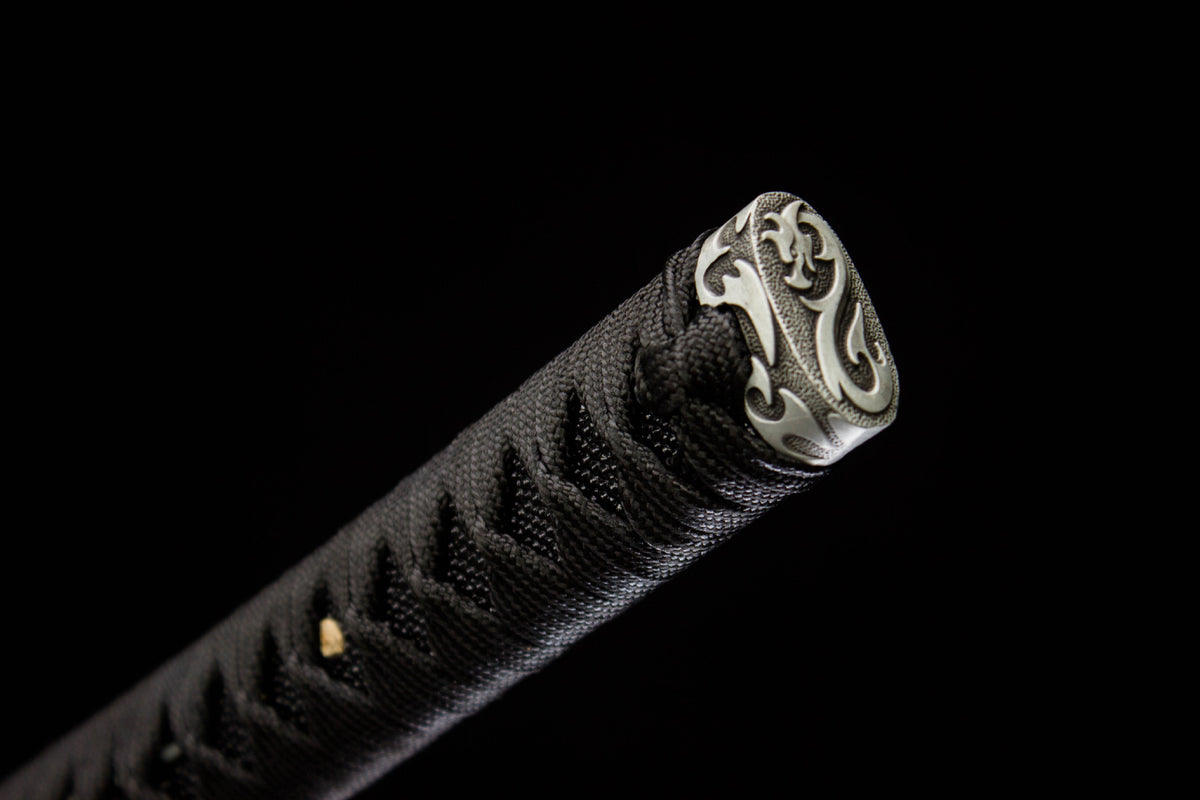 Close-up of the Moonlit Dragon Katana’s black and gold handle wrap with an ornate end cap