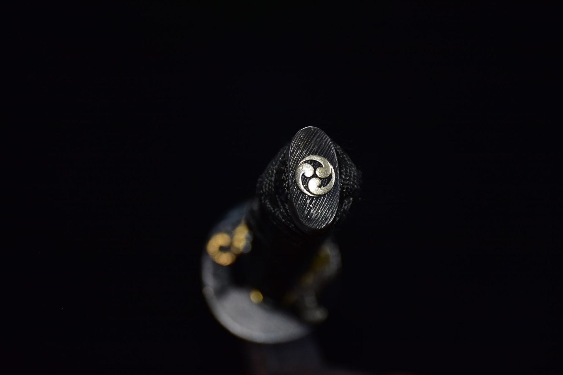 Katana kashira with silver-tone tomoe emblem