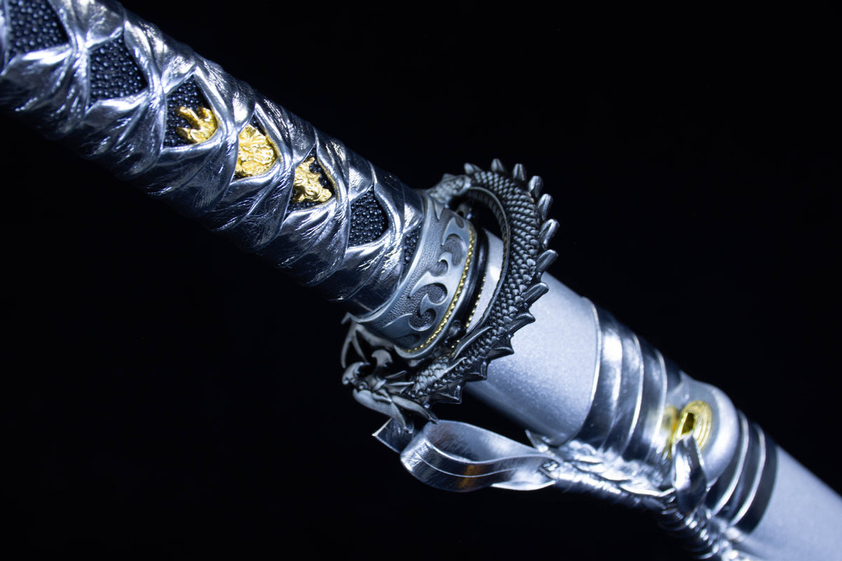 Close-up of the Silver Cloud Katana’s silver handle wrap, ornate fittings, and dragon-illustrated saya