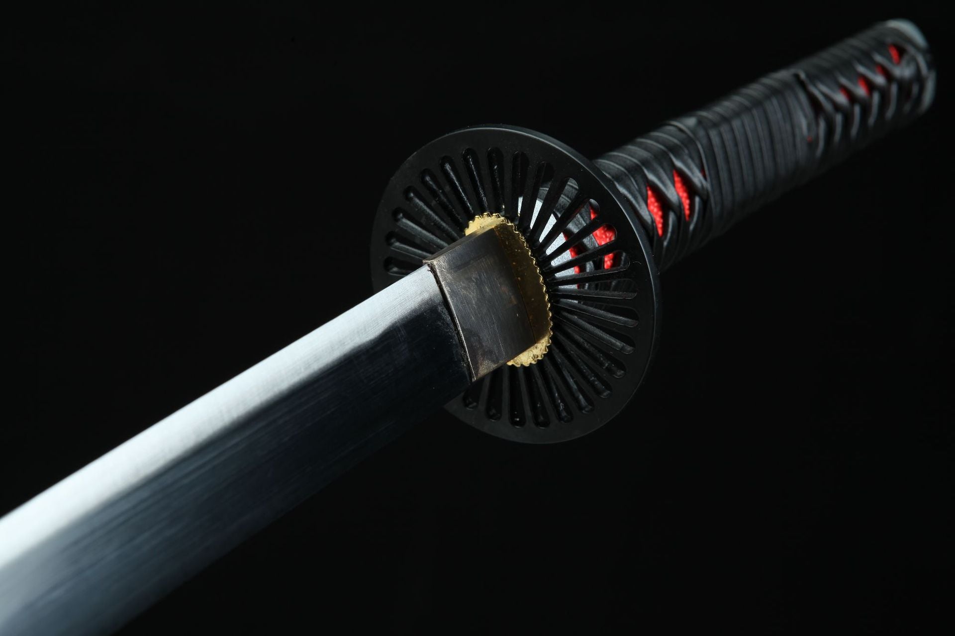 Black round handguard of Tanjiro's Nichirin katana with a radiating hollow design, highlighting its unique style and intricate details.