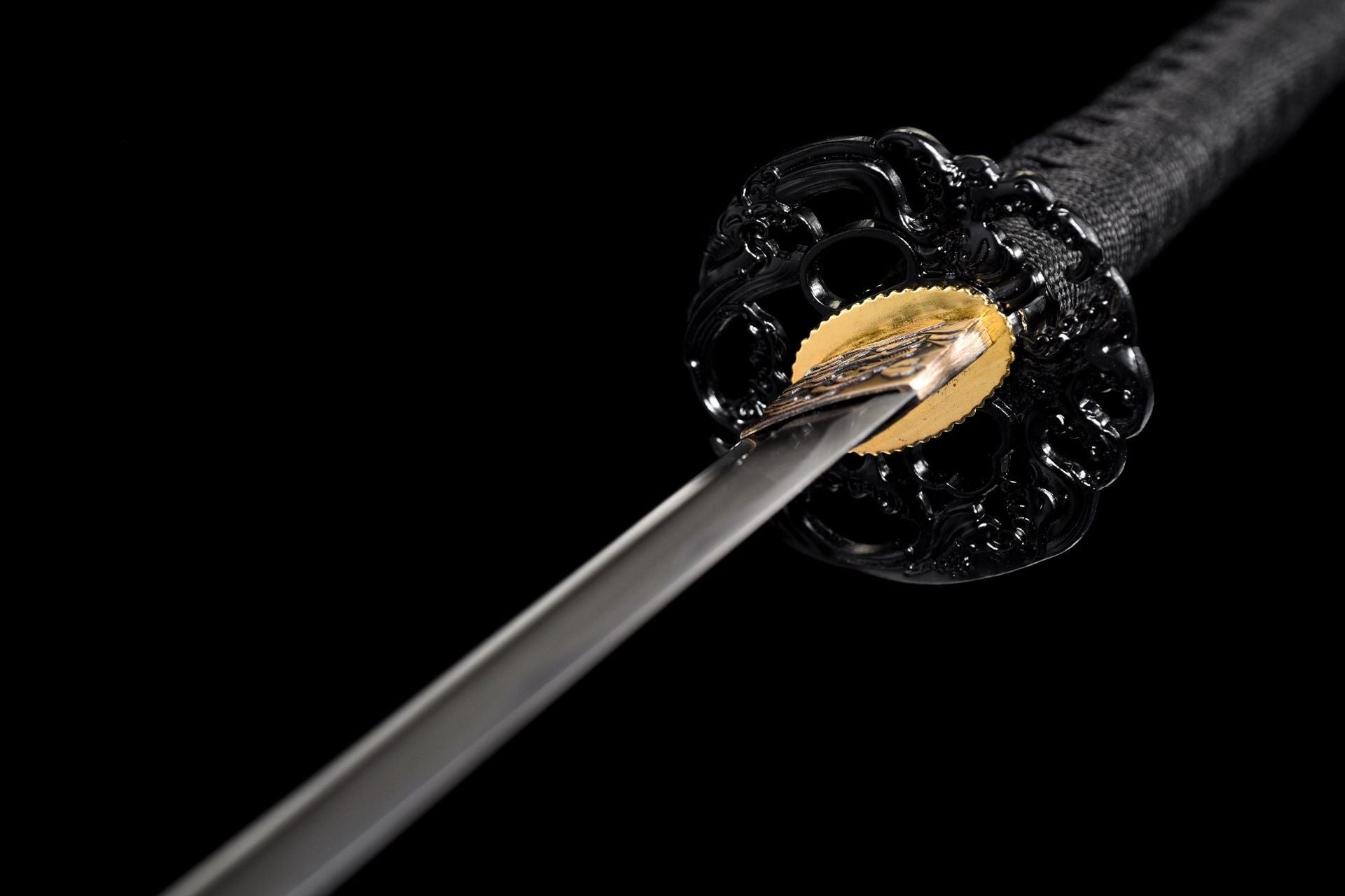 Black tsuba and gold-tone fitting detail near the blade base