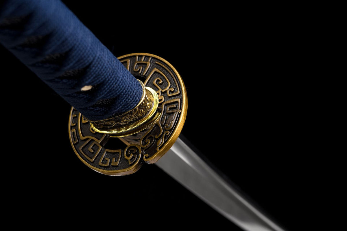 Round openwork tsuba with dark and gold-toned geometric detailing