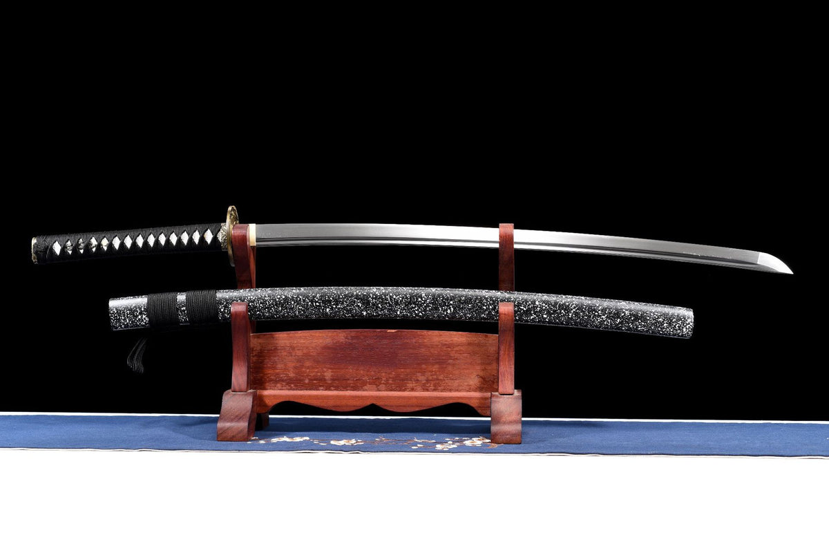 Inkstorm Samurai Katana displayed unsheathed above its splatter-finish saya