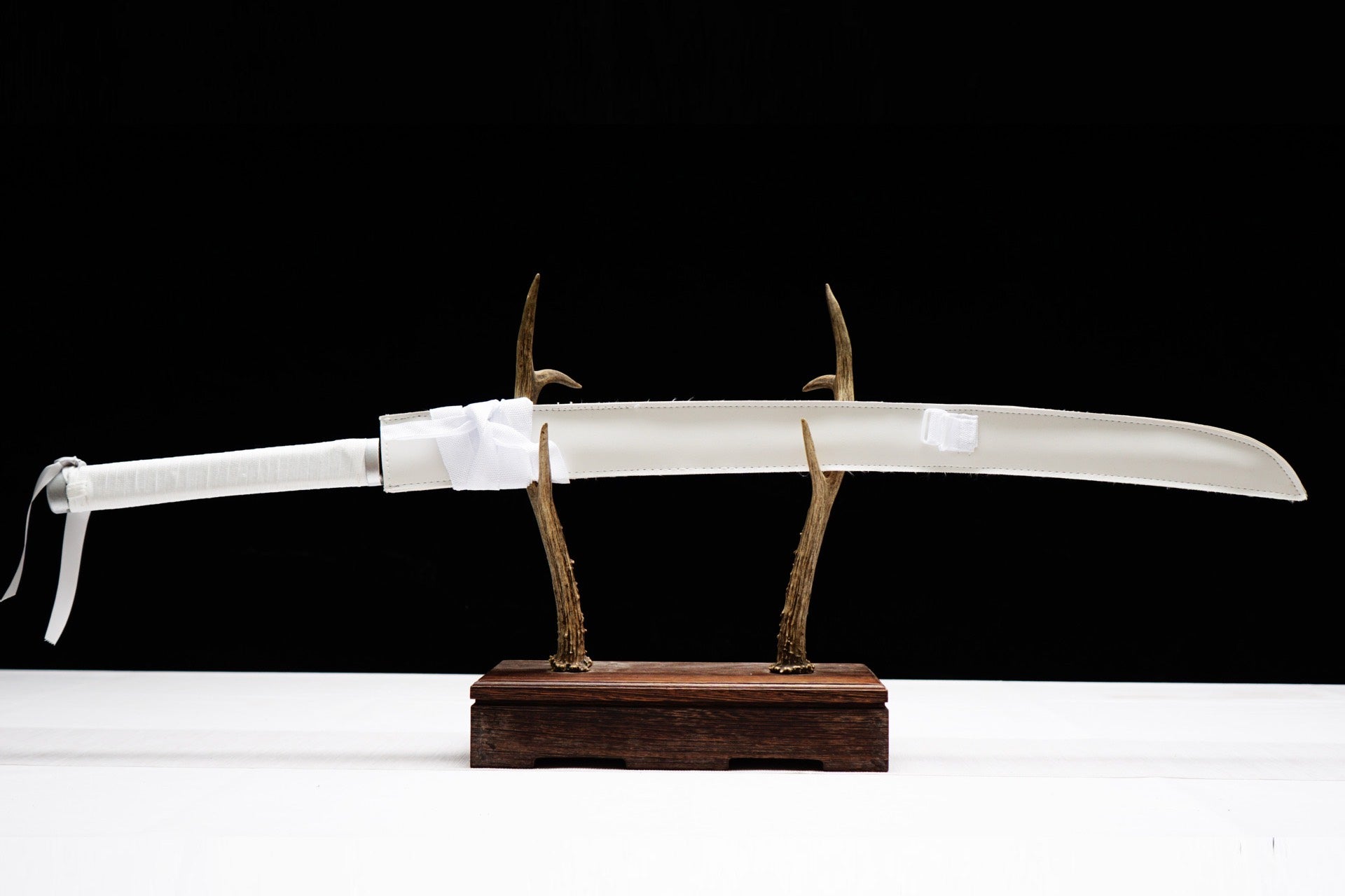 Full sheathed view with white scabbard and white wrapped handle