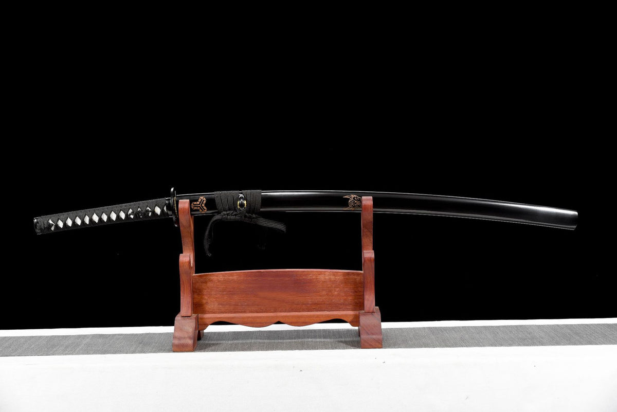 Black lacquered saya with copper-toned carved crest motif