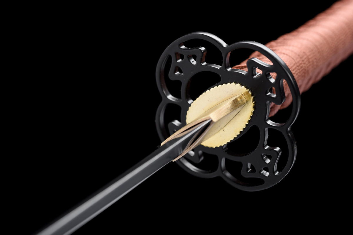 Black multi-lobed openwork tsuba with a brass-toned habaki