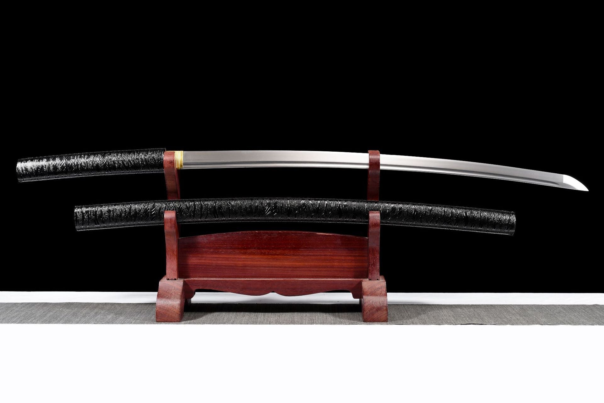 Sharpened full tang katana displayed beside its black saya