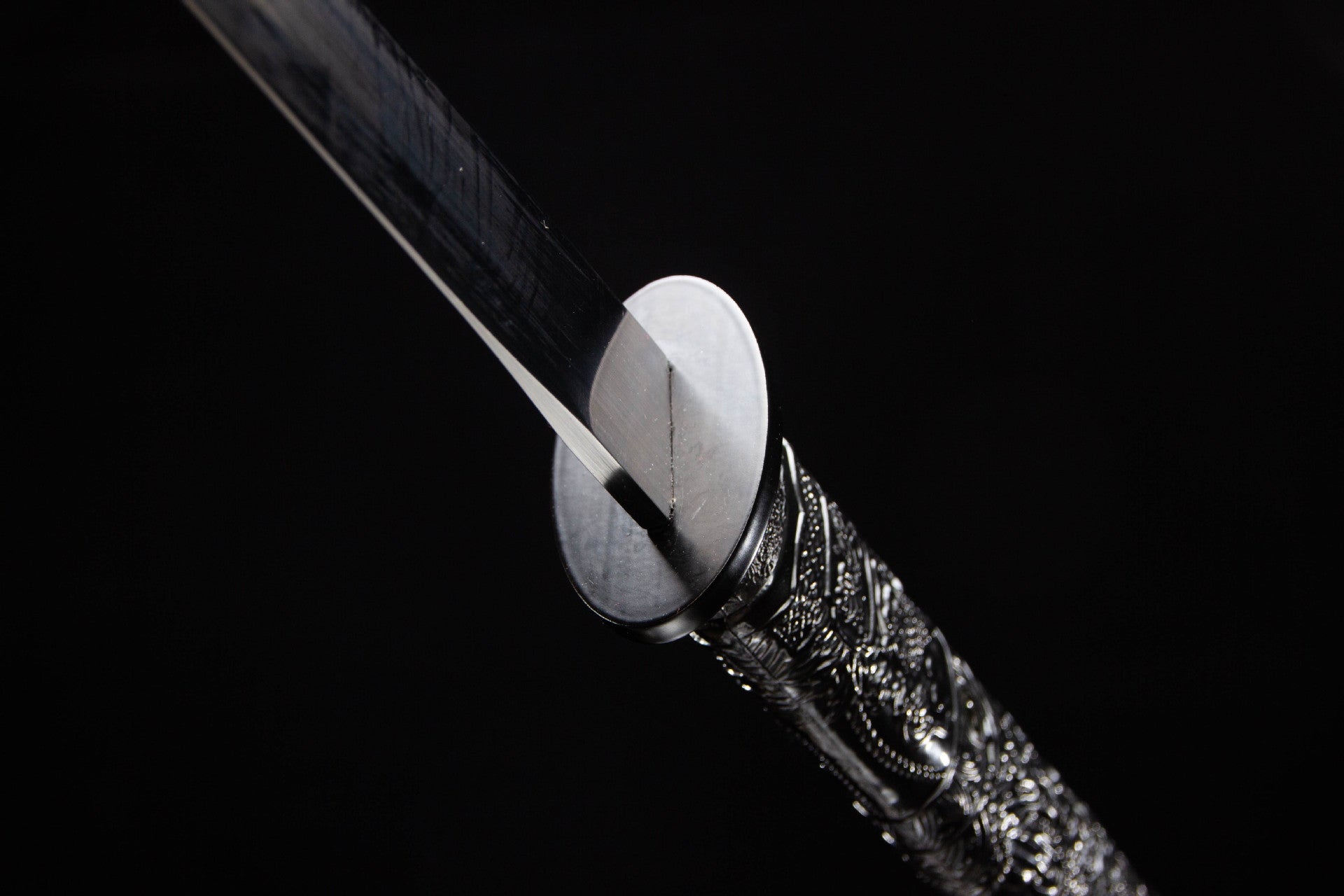 Compact black guard and polished blade base on the full tang katana