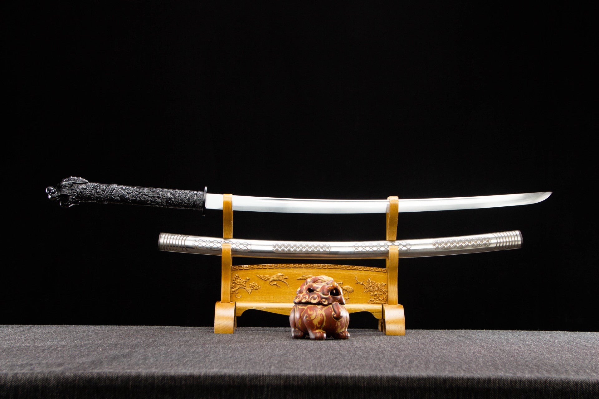 Sharpened Silver Dragon Katana displayed above its scale-pattern saya