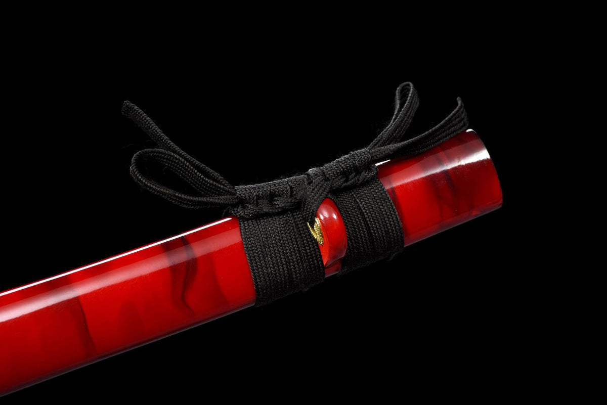 Dark and gold-toned pommel with black handle wrap