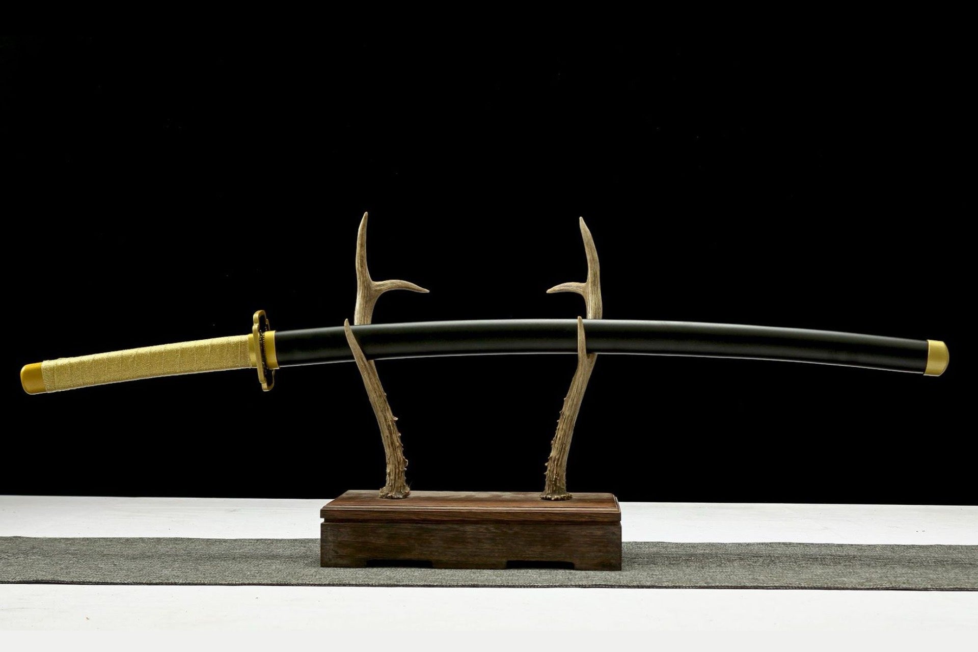 Full sheathed view of Yoriichi Tsugikuni Katana with gold handle wrap and black scabbard