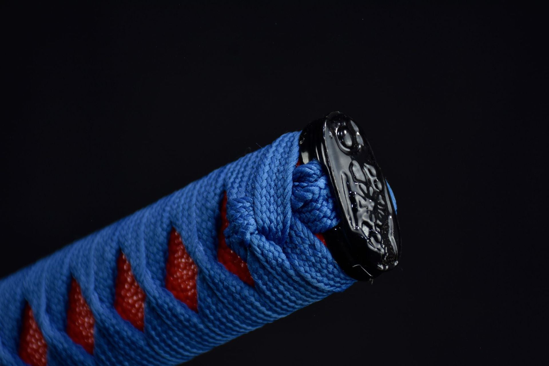 A sleek black katana kashira with elegant detailing
