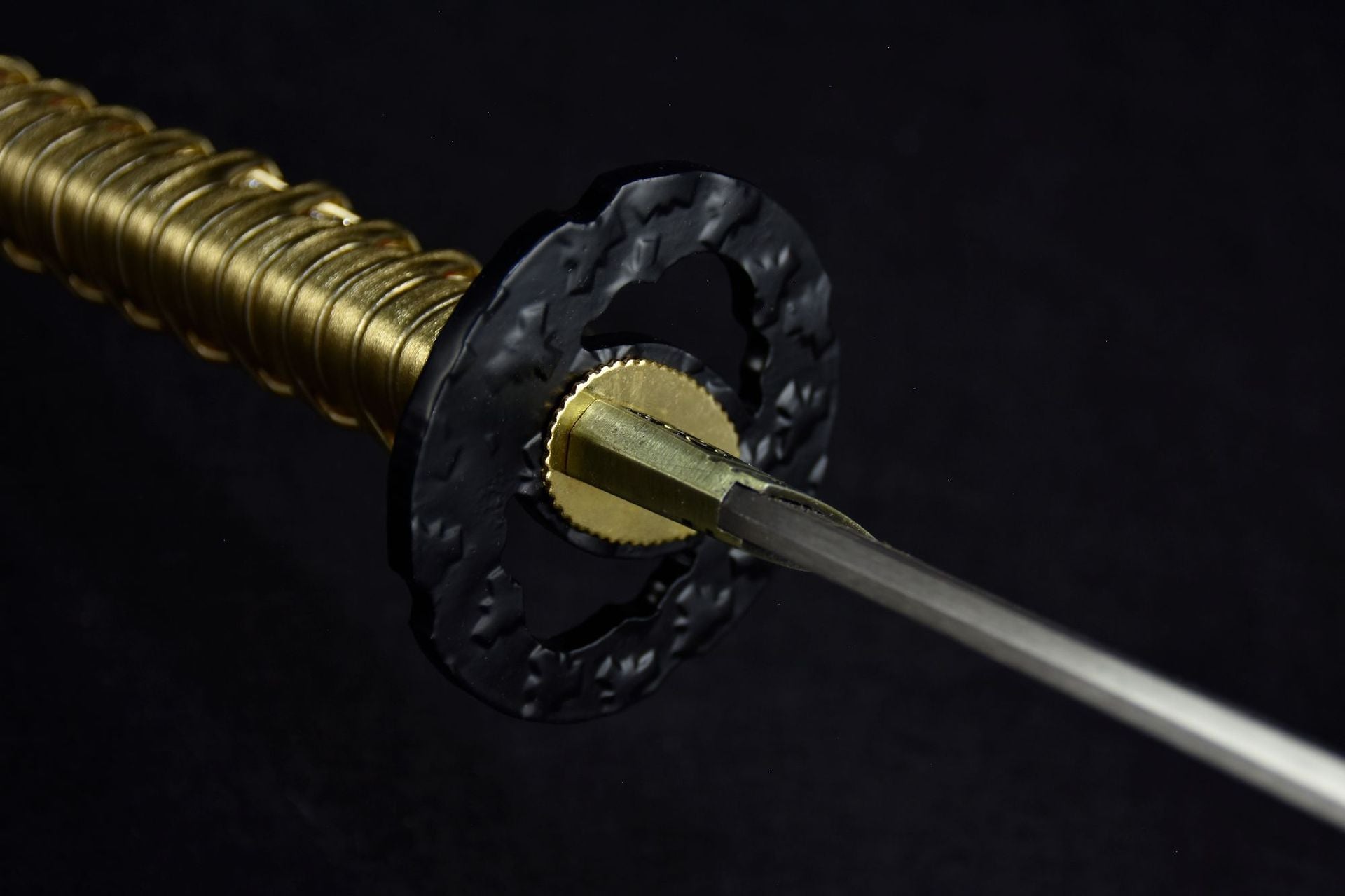 A detailed view of the black katana tsuba