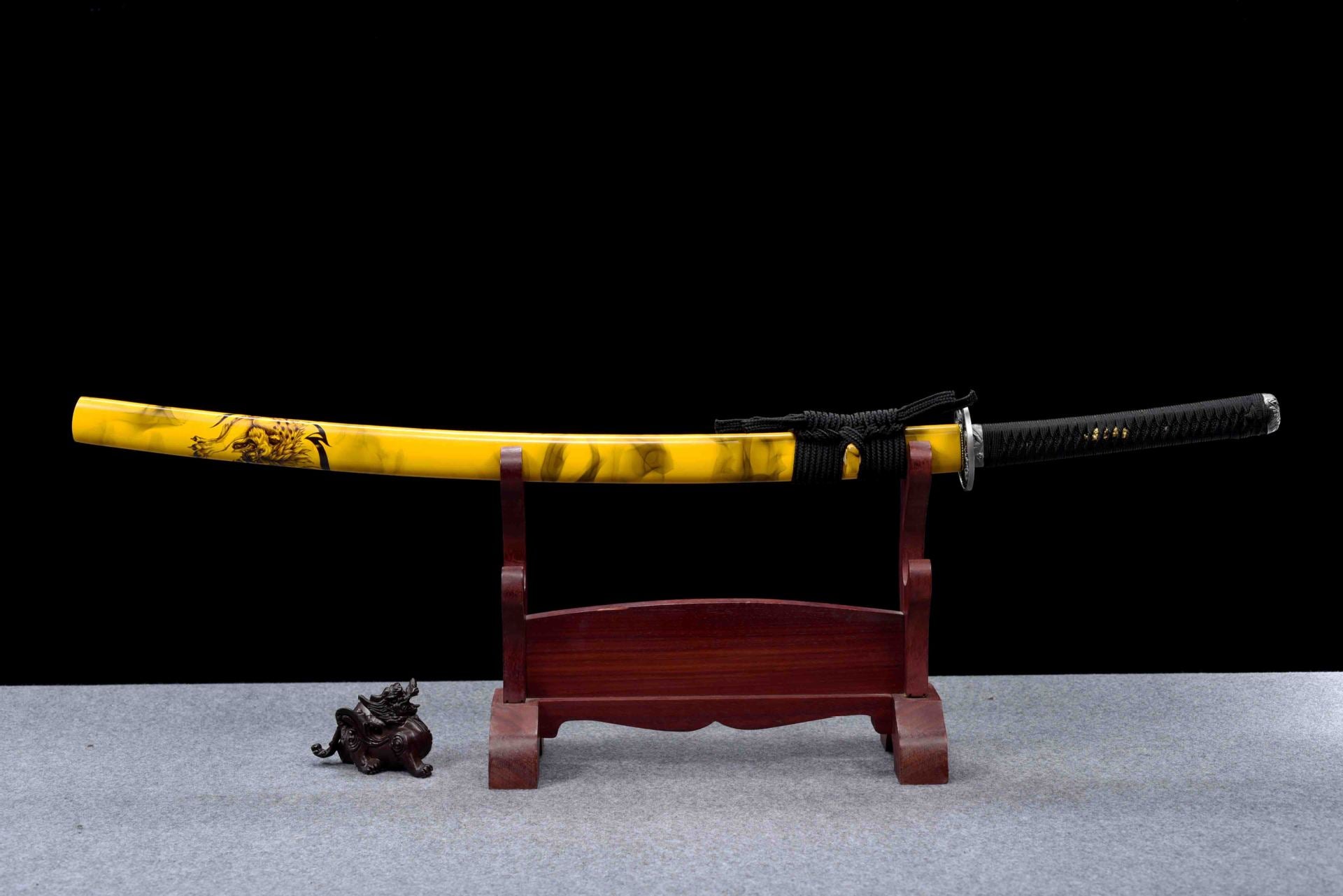 A full view of the black katana paired with a yellow saya, showcasing the striking contrast and elegant design.