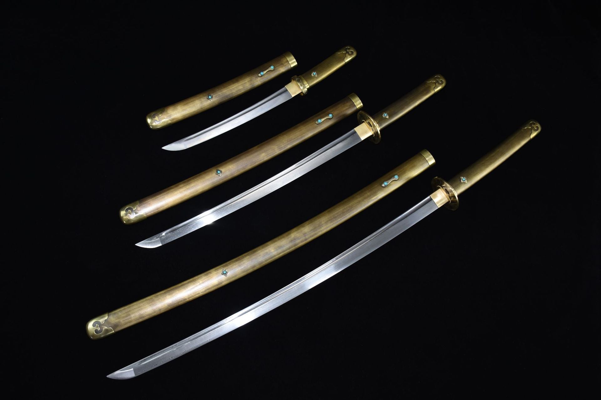 A collection of samurai swords with copper fittings, showcasing various sizes with intricate brass and turquoise details on the handles and pommels.