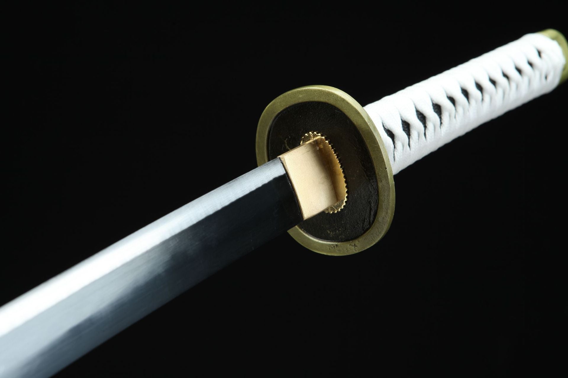 A close-up of the round Wado Ichimonji guard and the handle wrapped in white cord.