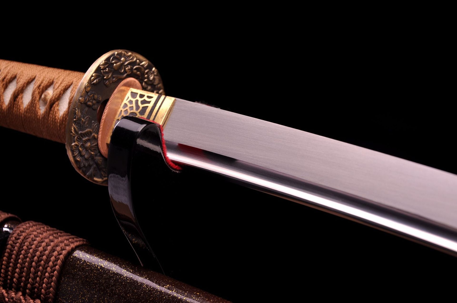 A close-up of the Fallen Sakura samurai sword's blade and guard, highlighting the polished blade and floral-patterned guard.