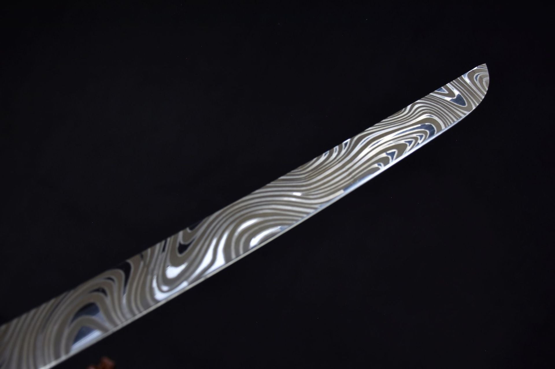 Close-up of a Damascus samurai sword blade showing the folded pattern