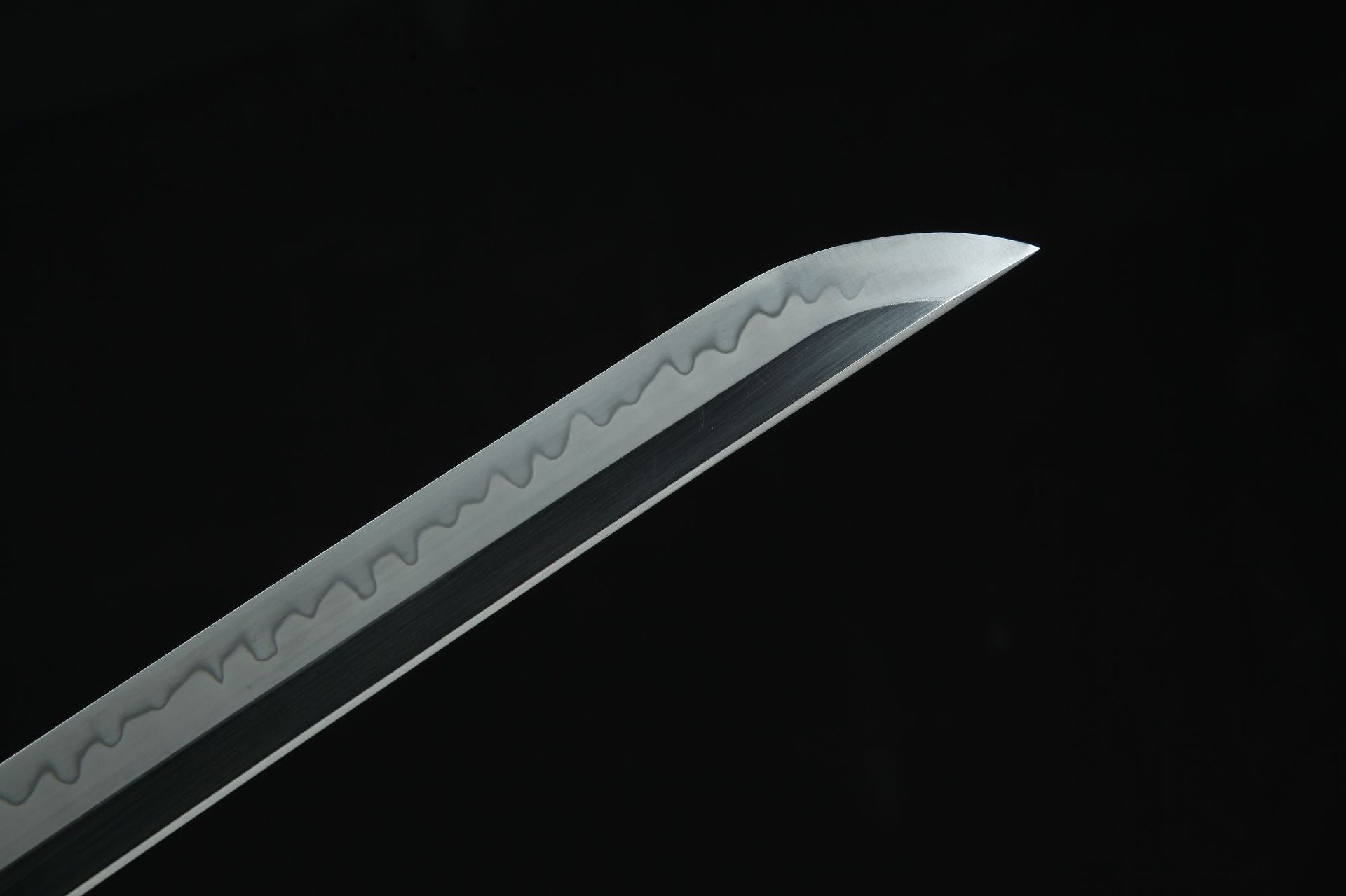 Close-up of the Golden Loong samurai sword's blade tip with a wavy hamon pattern.