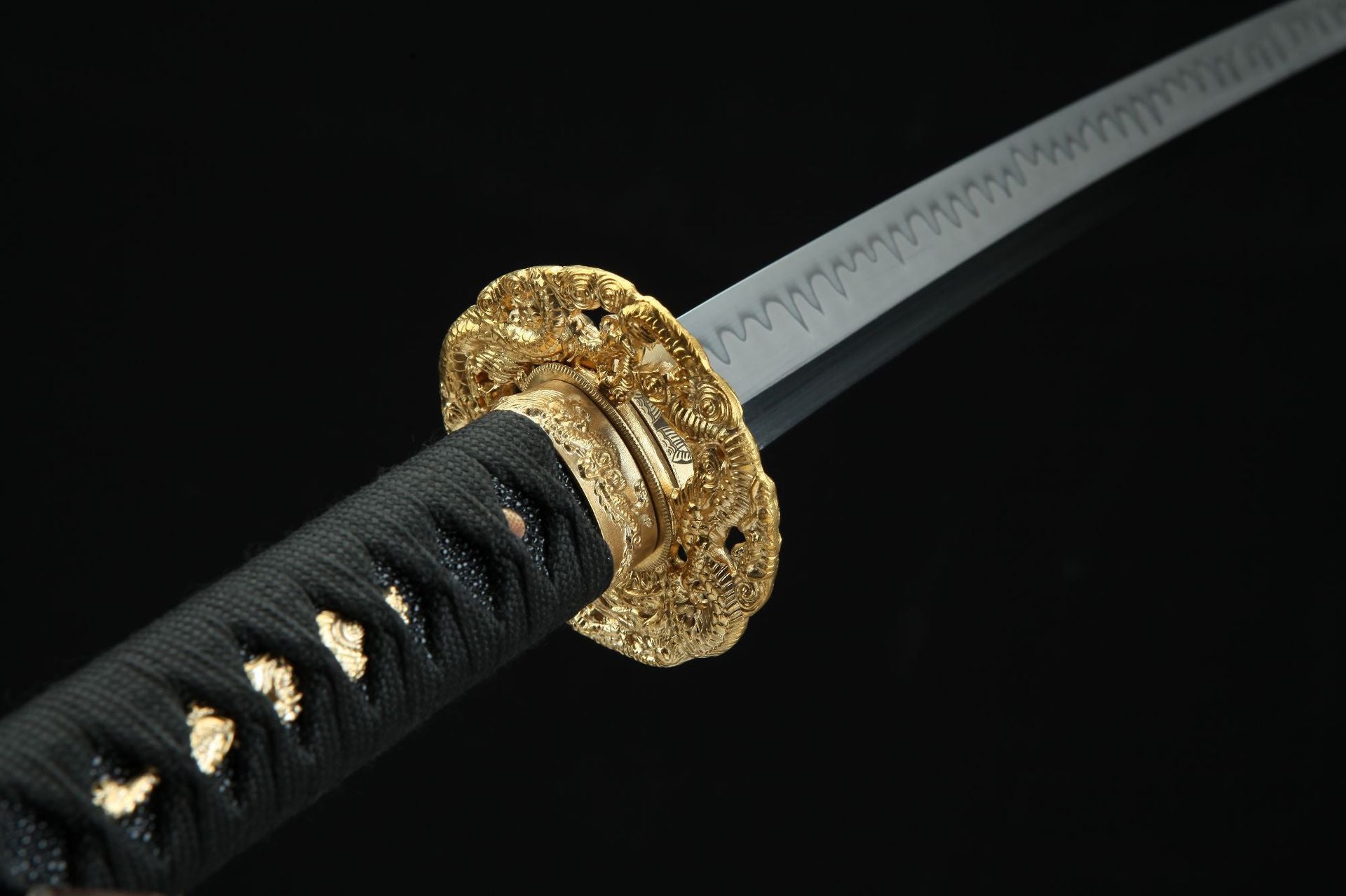 Close-up of the Golden Loong samurai sword's golden guard and polished blade with a wavy hamon pattern.