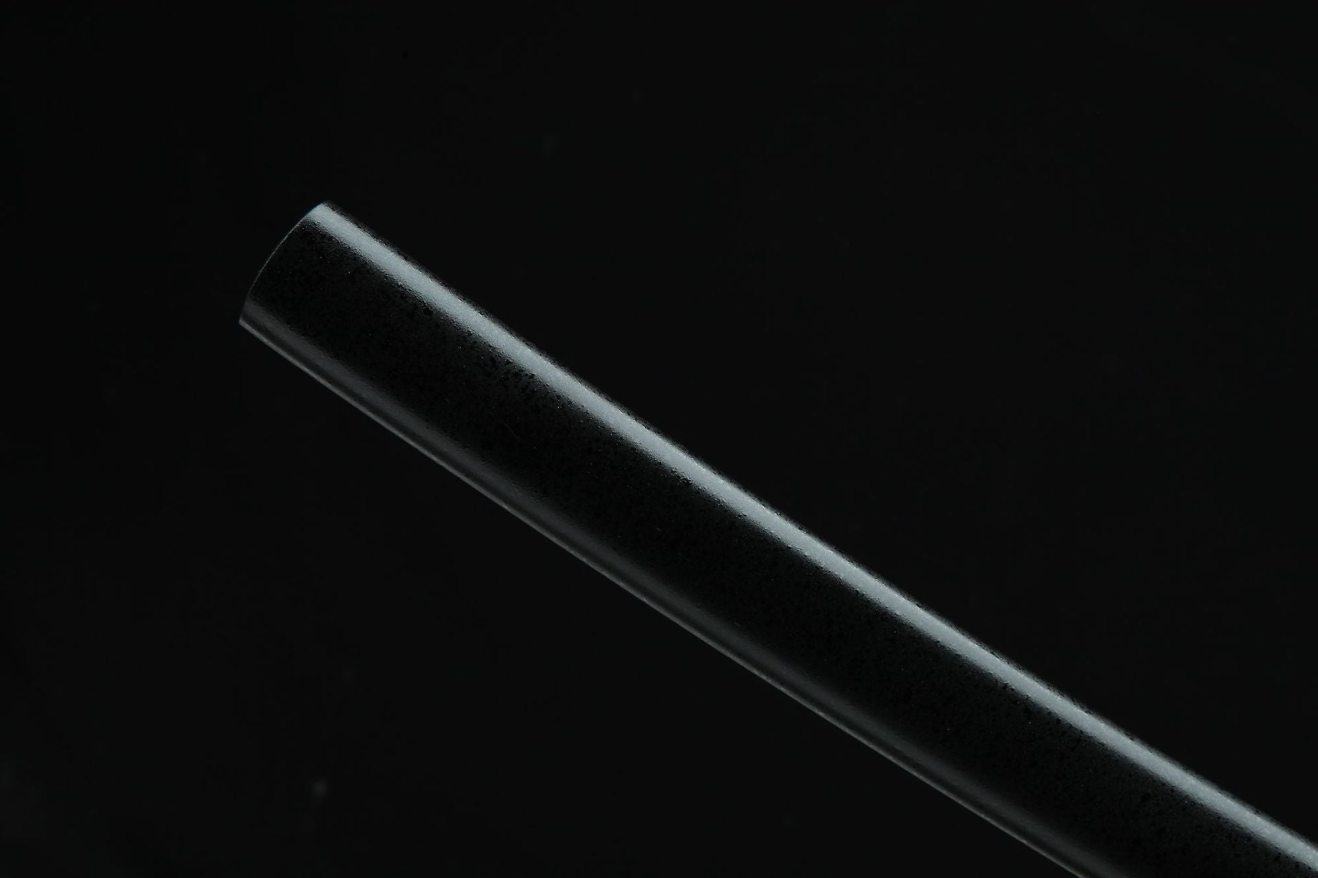 Close-up of the Golden Loong samurai sword's black sheath end with a smooth finish.
