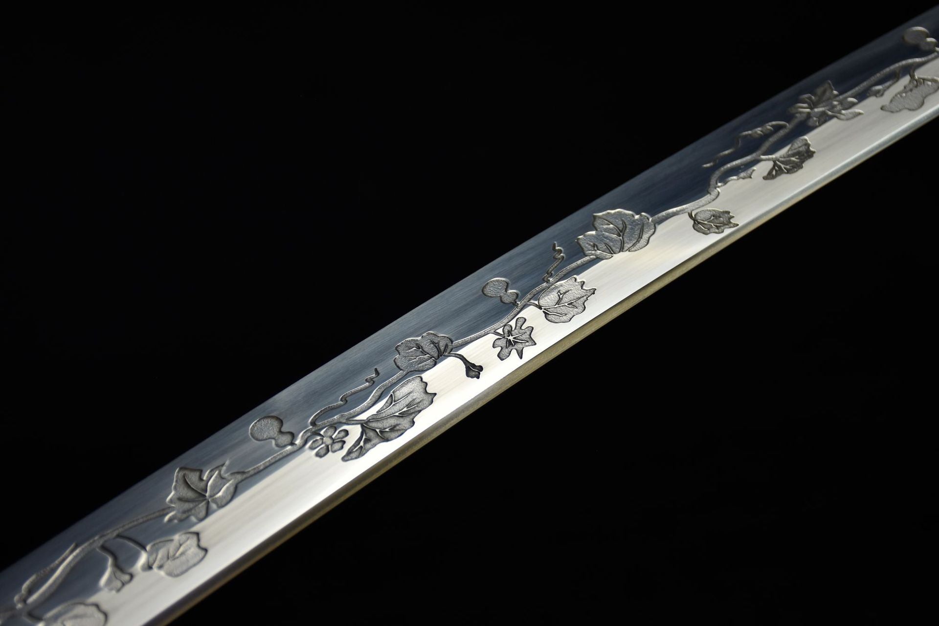 Close-up of the katana blade featuring an intricately carved gourd pattern, showcasing fine etching details.