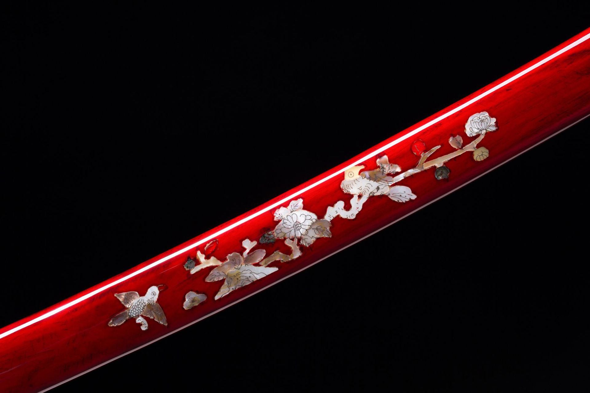Red saya with intricate silver inlays featuring floral and fauna motifs on a Loong katana.