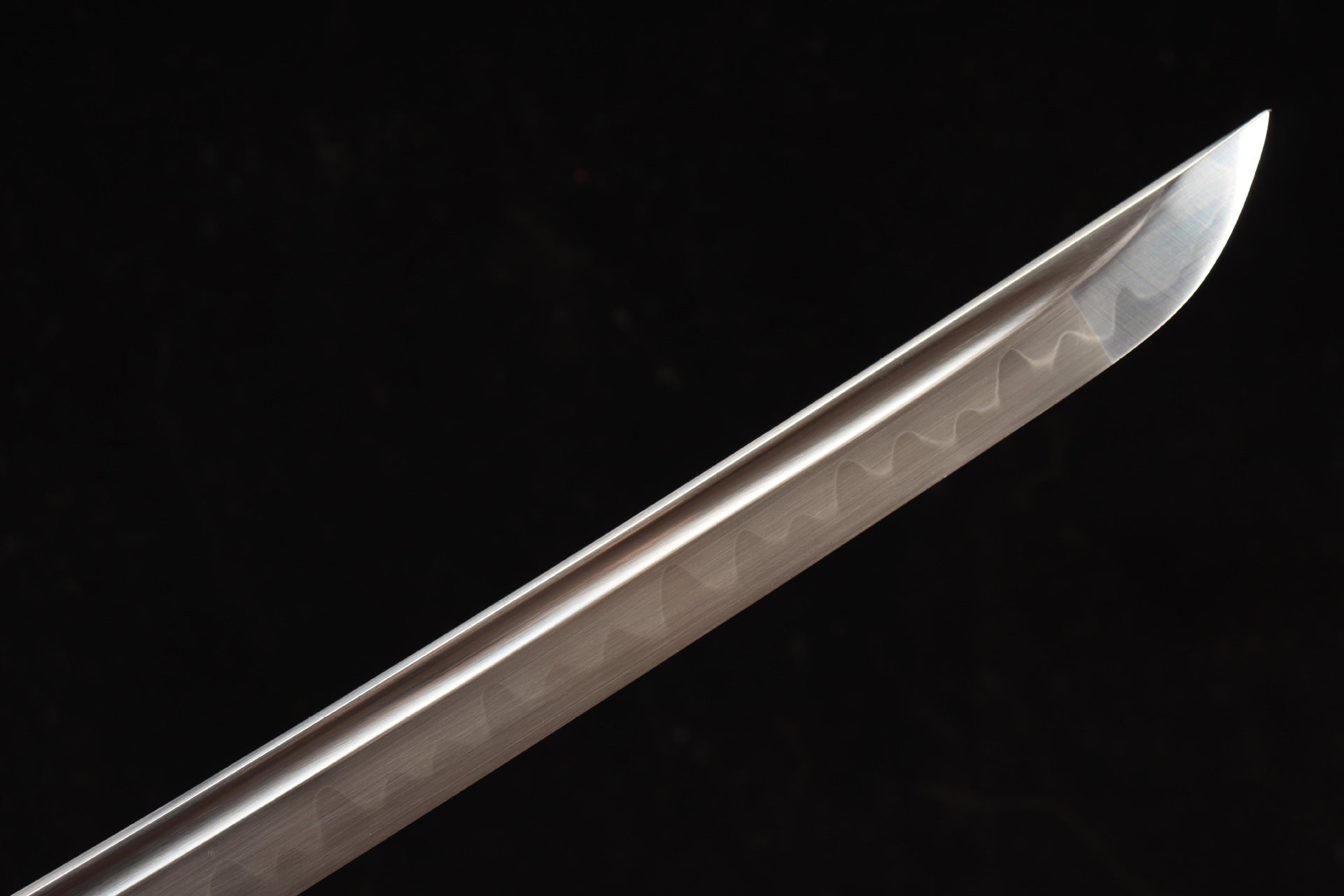 Close-up of the Nobunaga Tachi blade tip, crafted from T10 high-carbon steel with a clay-tempered hamon, highlighting its sharp edge and craftsmanship.