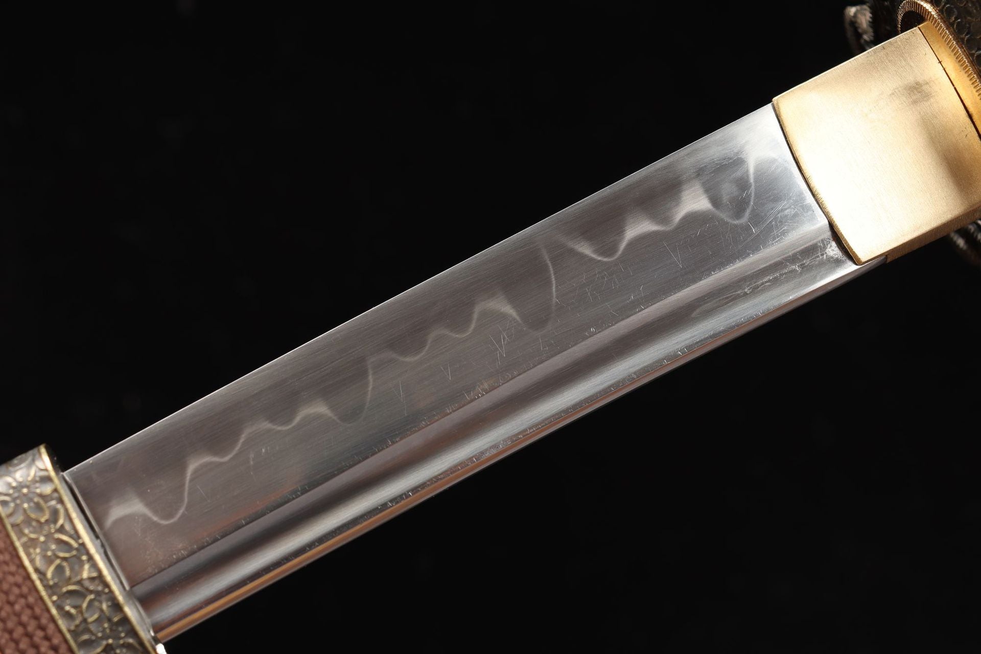 Close-up of the Nobunaga Tachi blade, crafted from high-carbon steel with a visible hamon pattern and full tang design, showcasing precision and durability.