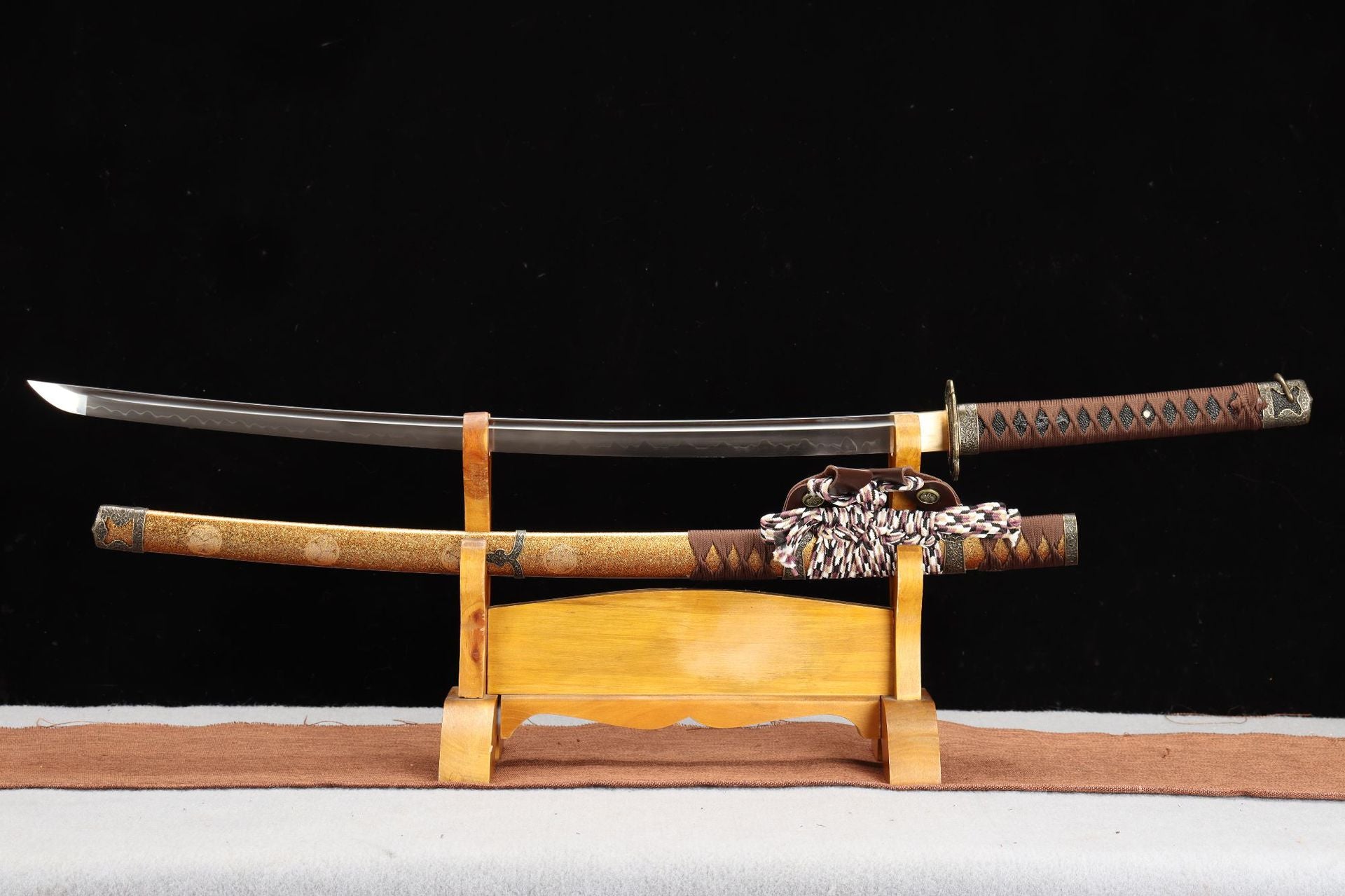 Nobunaga Tachi, a traditional Japanese tachi sword with a curved blade, ornate scabbard, and wooden display stand.