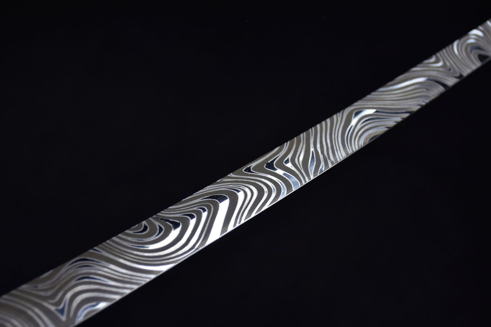 A samurai sword blade with intricate patterns on a black background