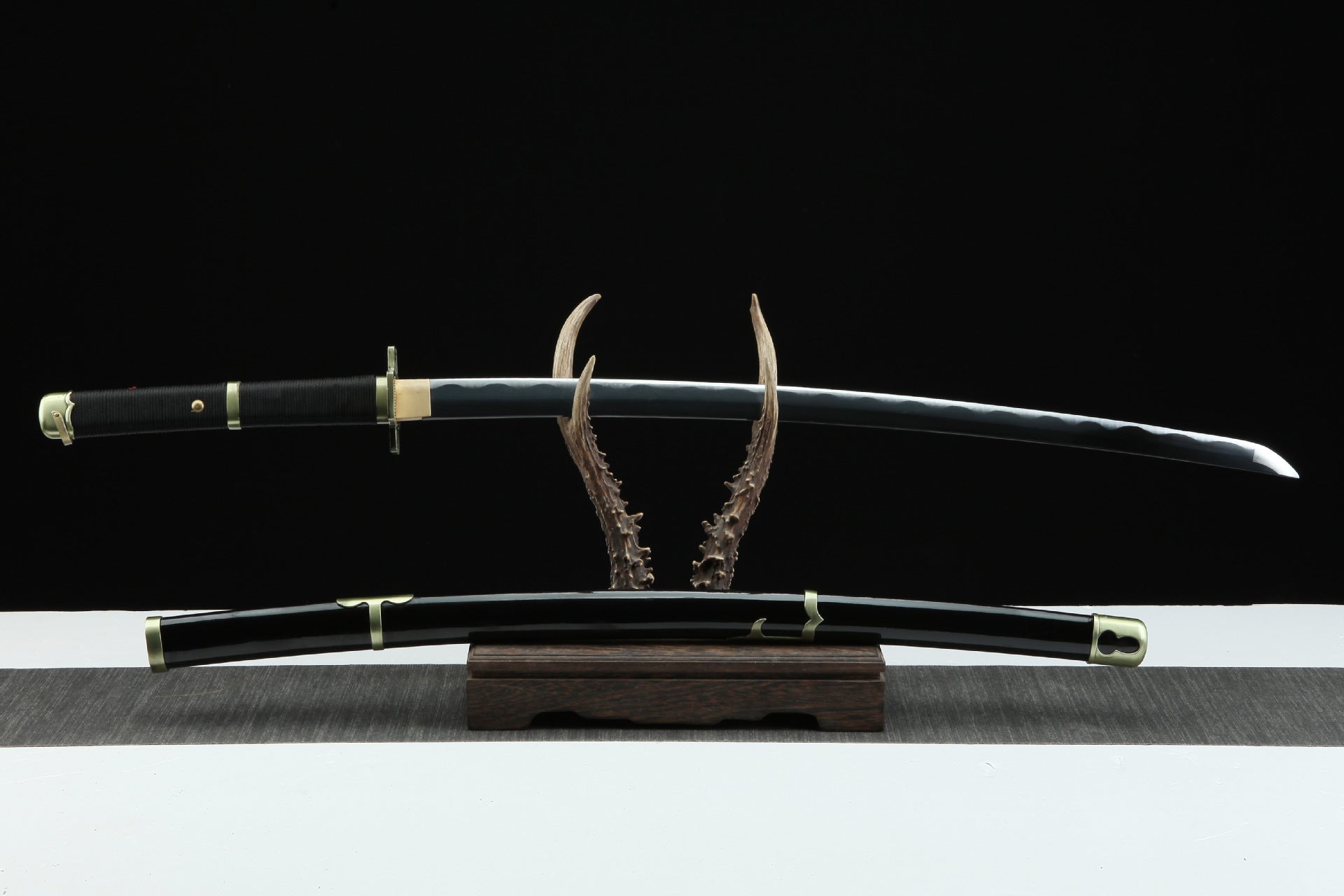 A black Yubashiri sword displayed on a stand, featuring a white blade and black sheath, once wielded by Roronoa Zoro.